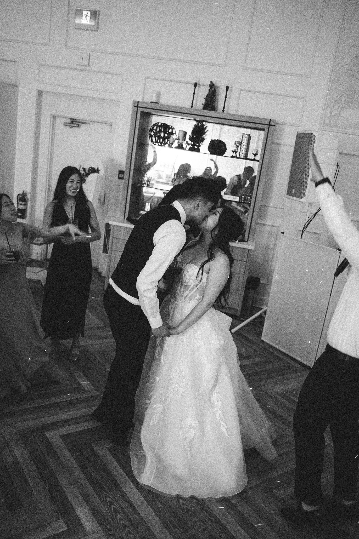 Bride and groom share a kiss on the dance floor at their wedding reception.