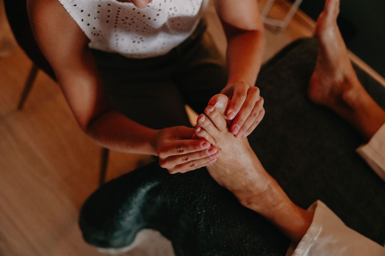 Therapist performing a relaxing foot massage on a client during a professional spa treatment session.