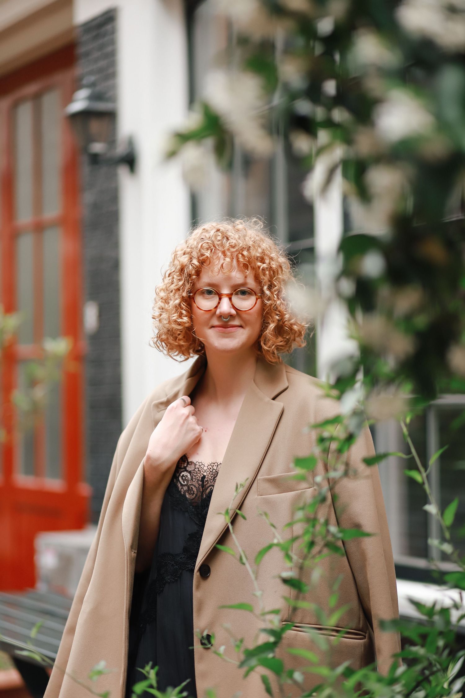 Portrait of a woman standing among greenery in the city