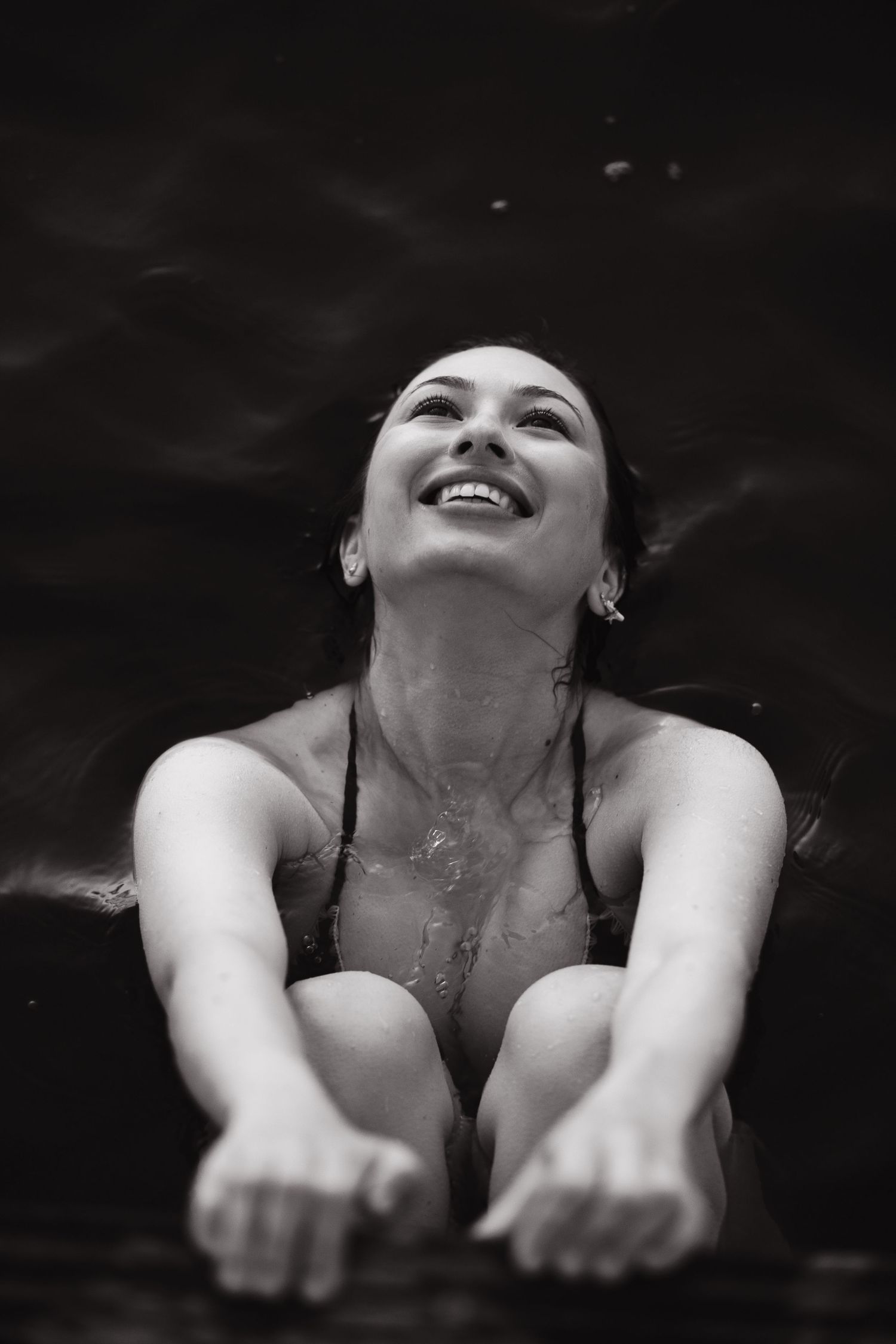 Black and white portrait of a woman laughing outdoors