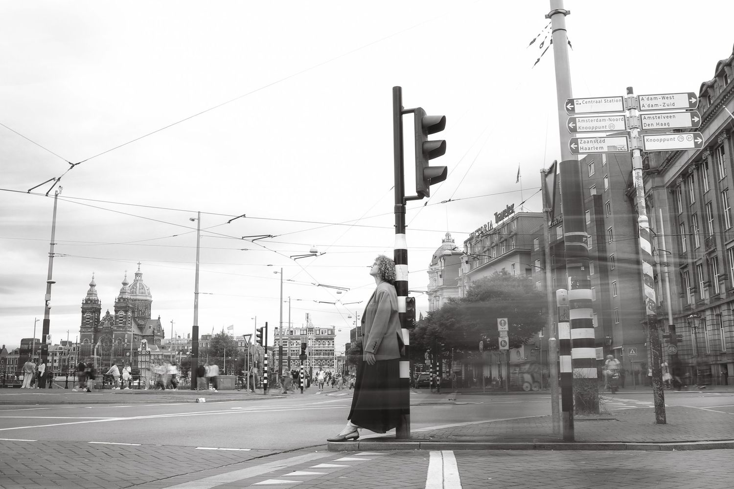 Black and white street portrait of a woman at a city crossing
