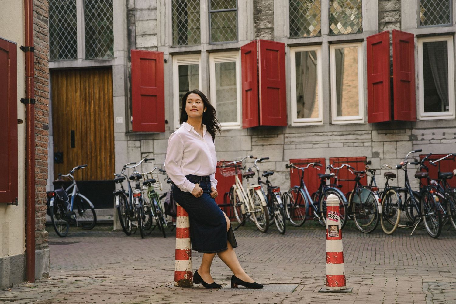 Woman walking through a city street lined with bicycles