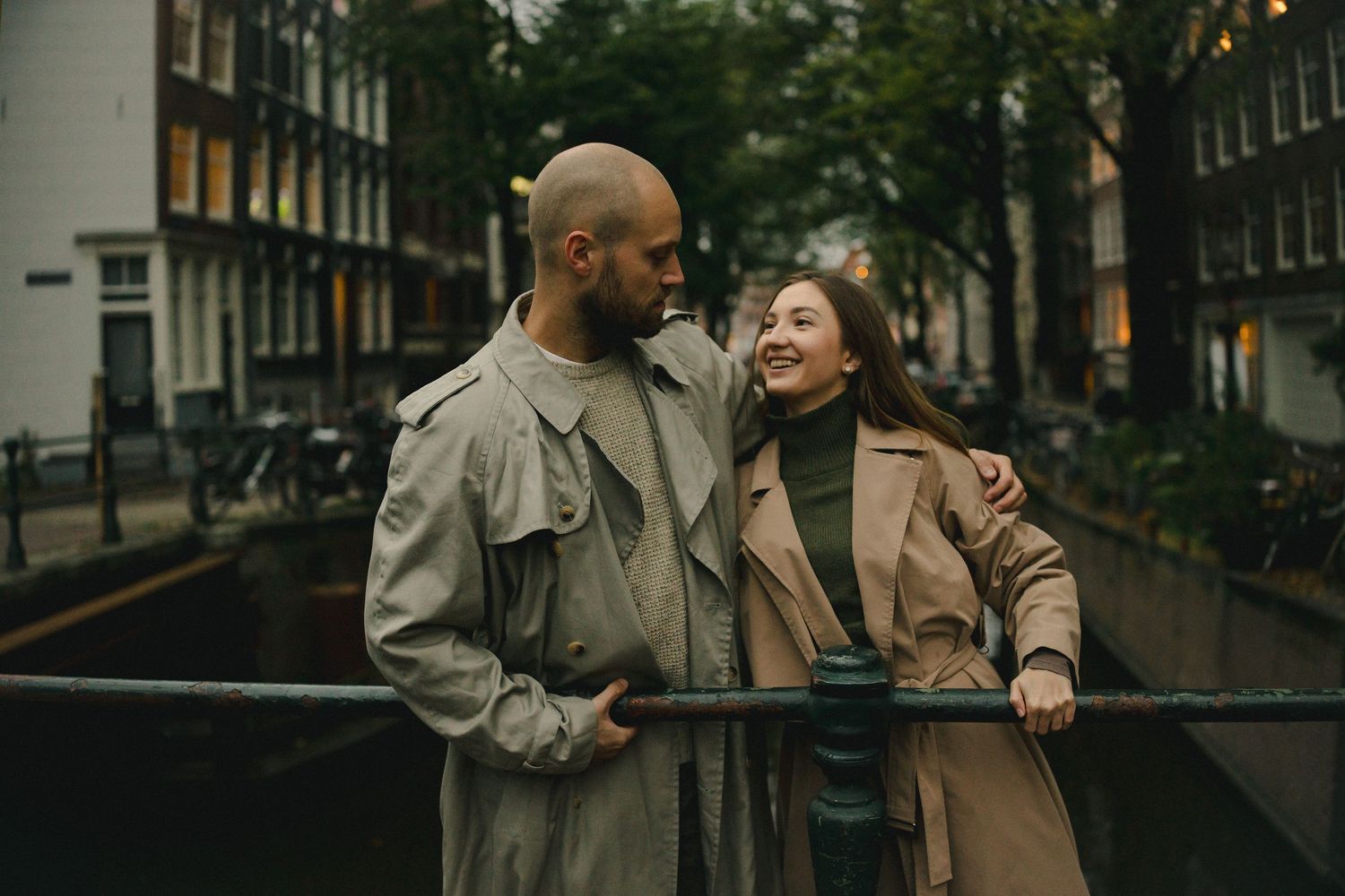 Couple smiling at each other beside a city canal