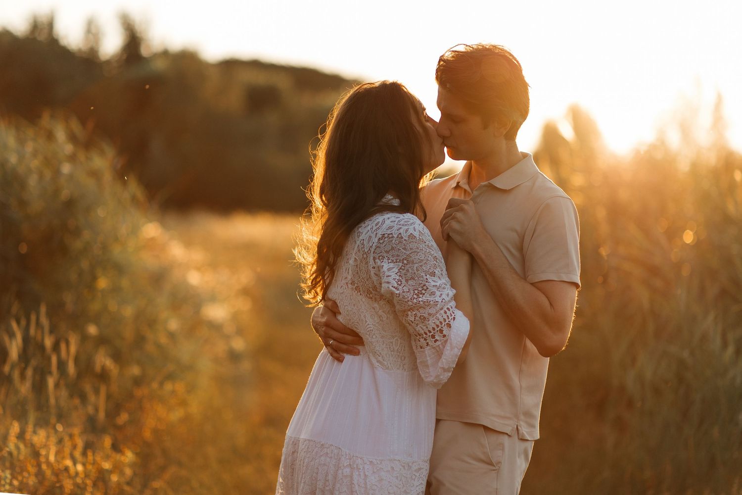 Couple embracing in a field at sunset