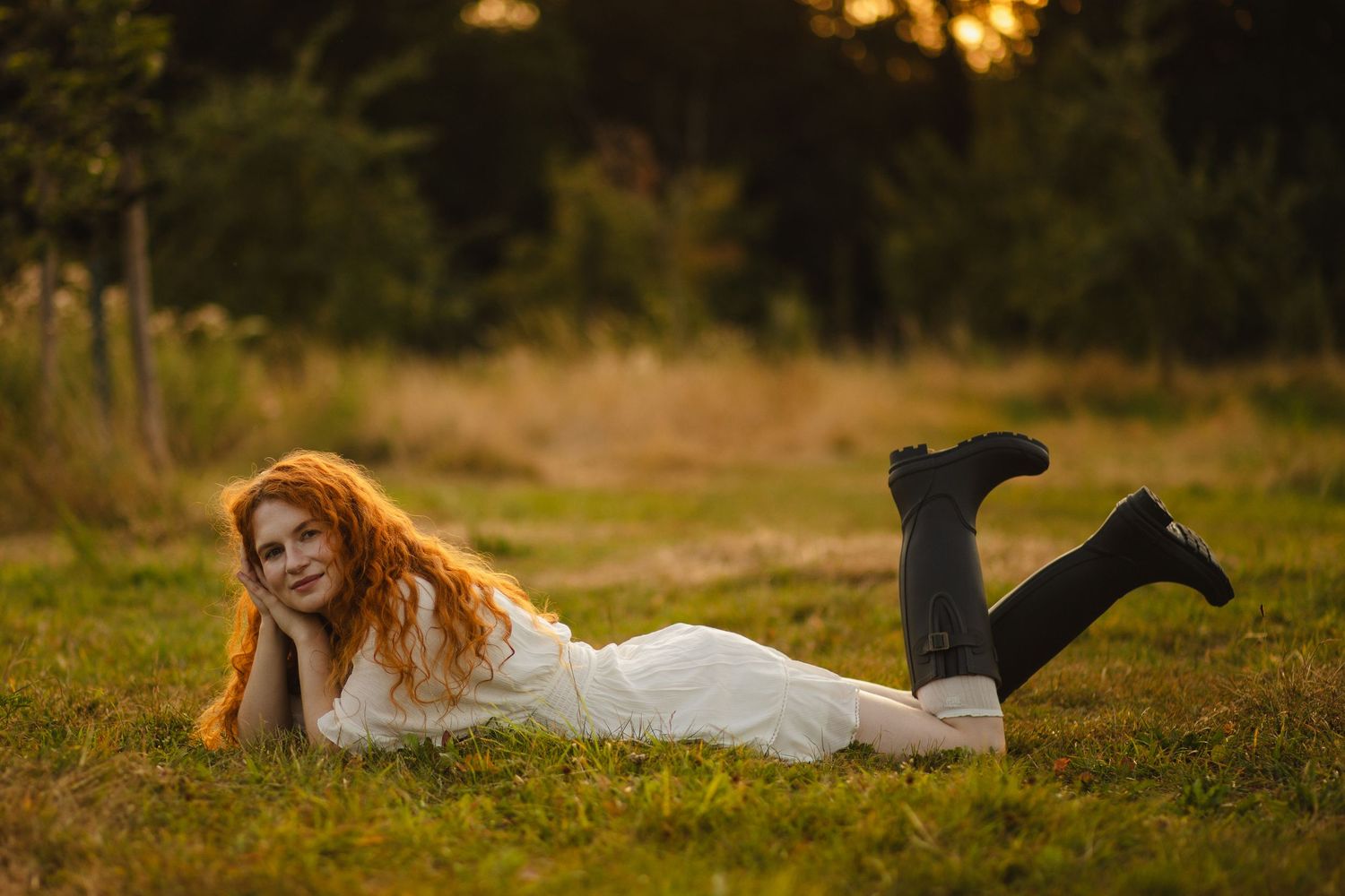 Woman lying in a field and smiling at the camera