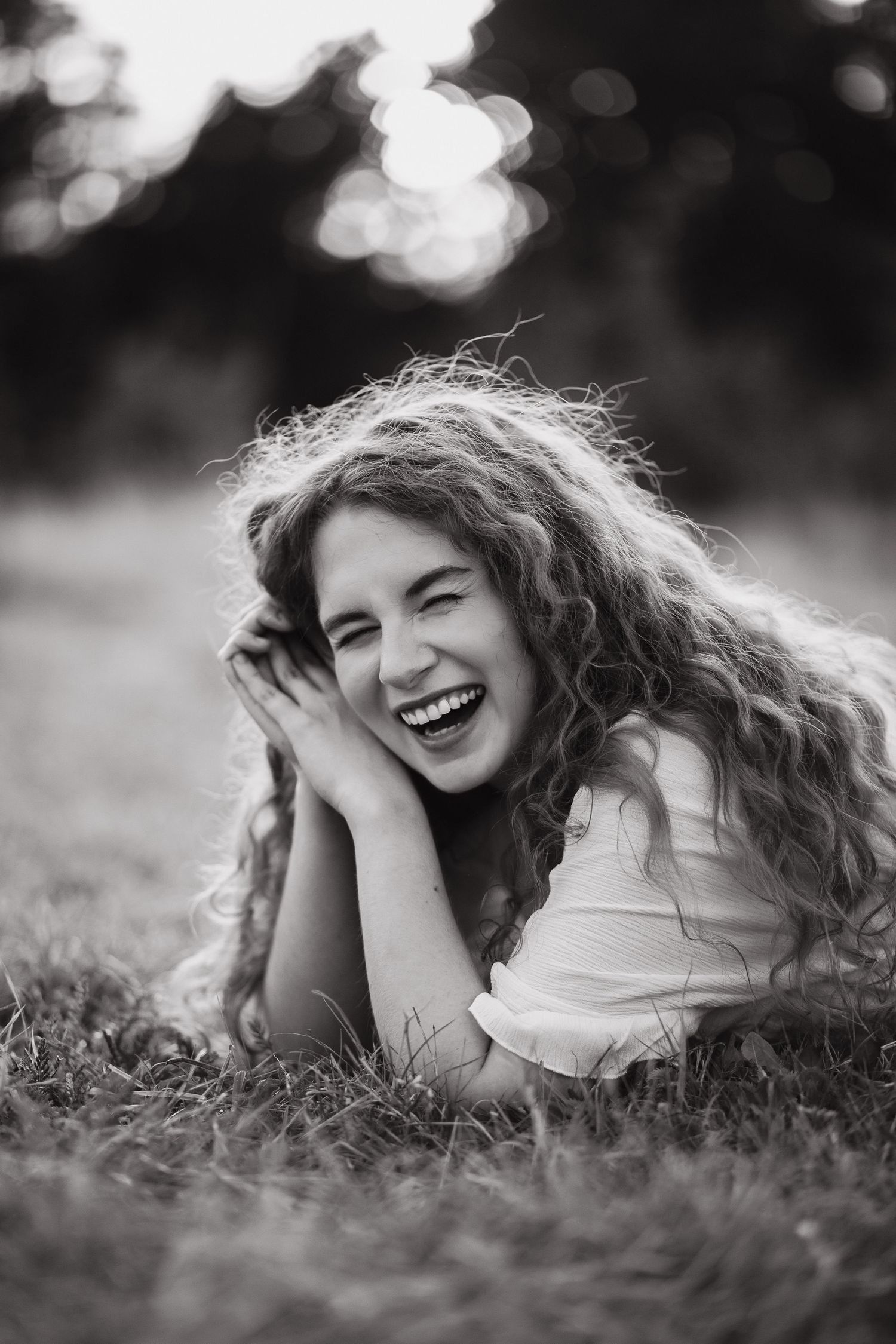 Black and white portrait of a woman laughing in a field