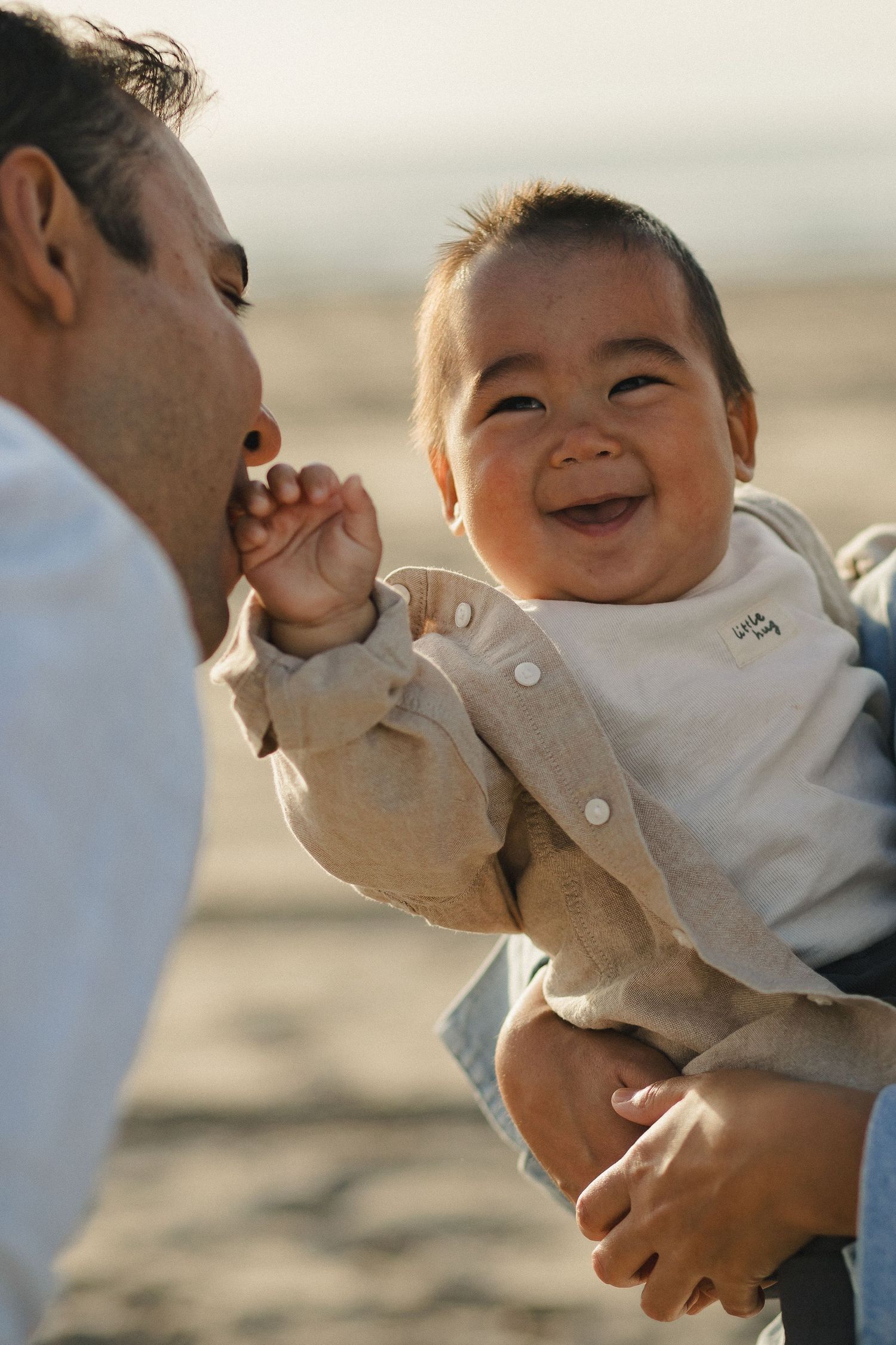 Baby laughing while being held by a parent