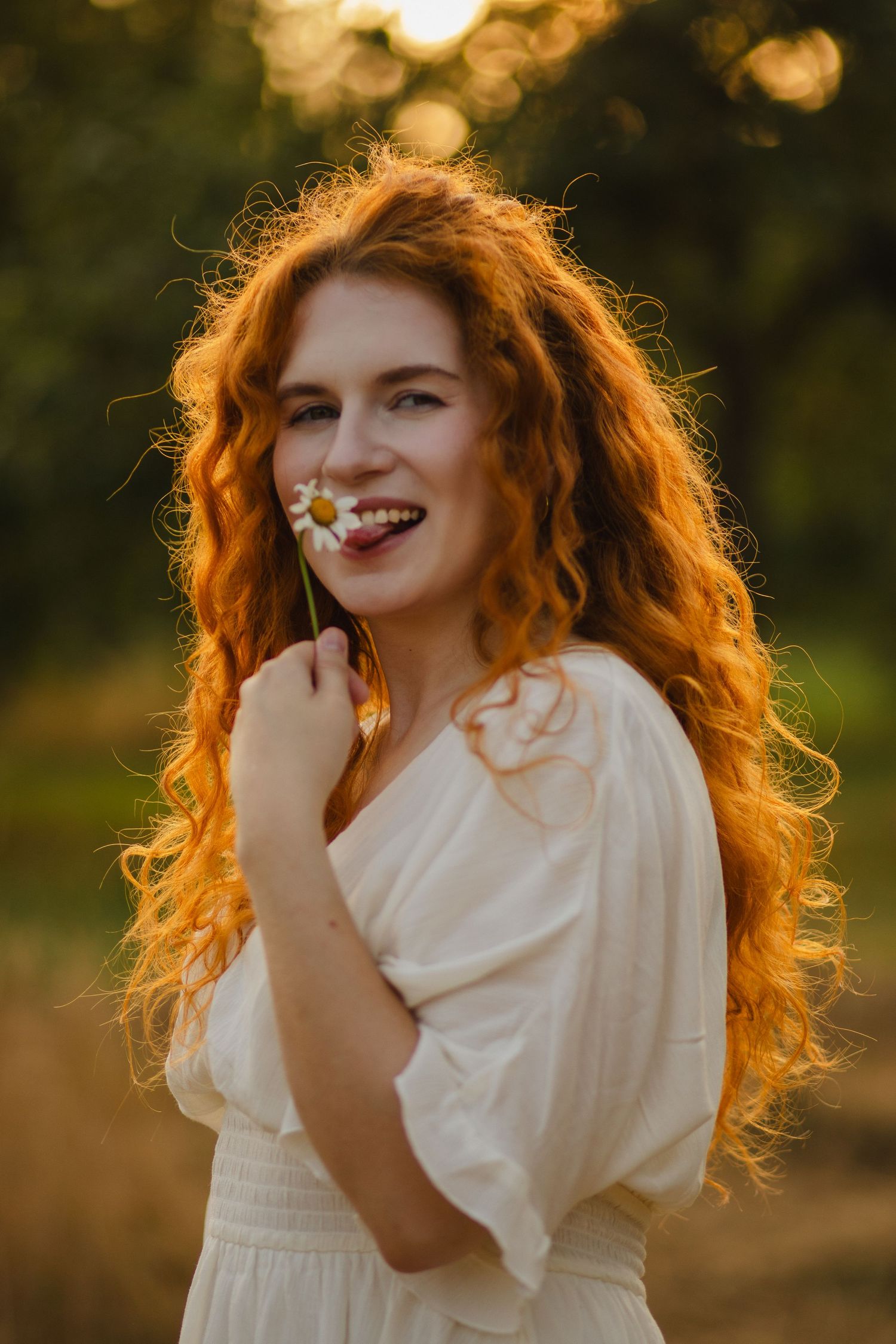 Portrait of a red-haired woman in a sunlit field