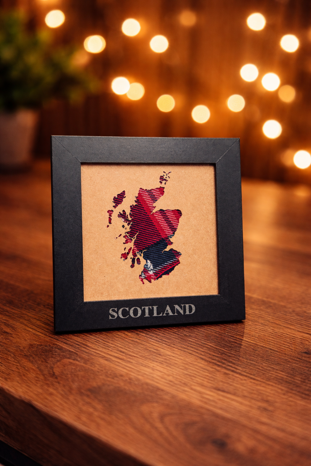 A series of decorative table cards showing Scotland's map silhouette against warm bokeh lights in the background.