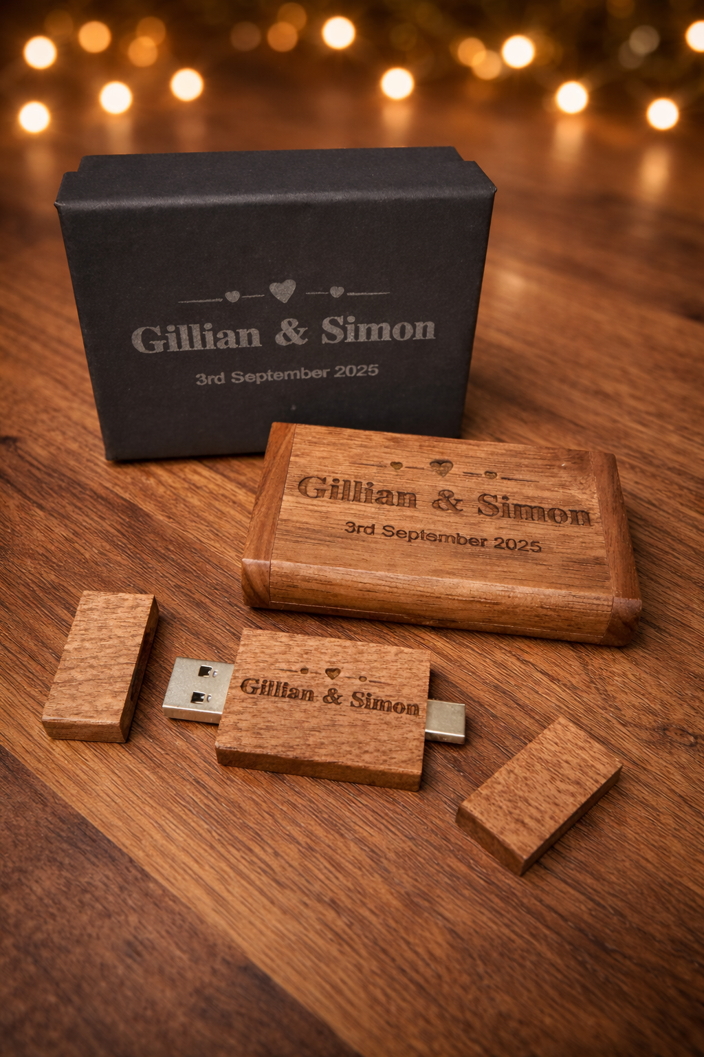Custom wooden USB drives and packaging boxes for wedding photography displayed on a wooden surface with warm lighting.