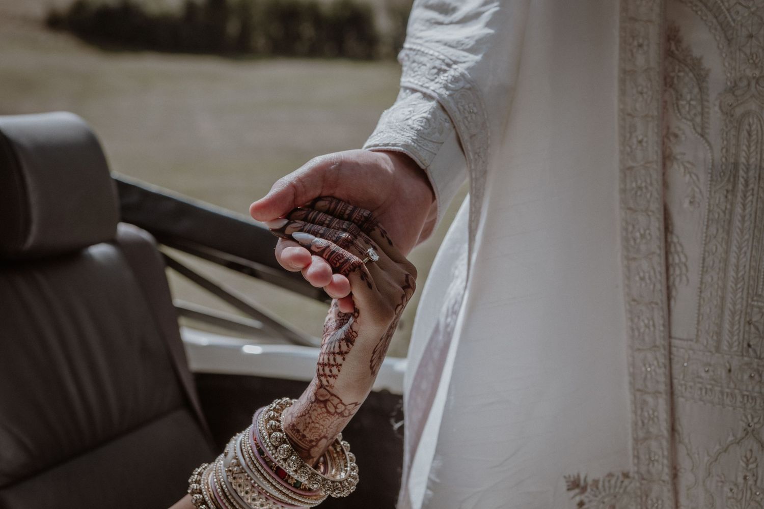 A close-up shot of traditional henna adorned hands during a wedding ceremony.