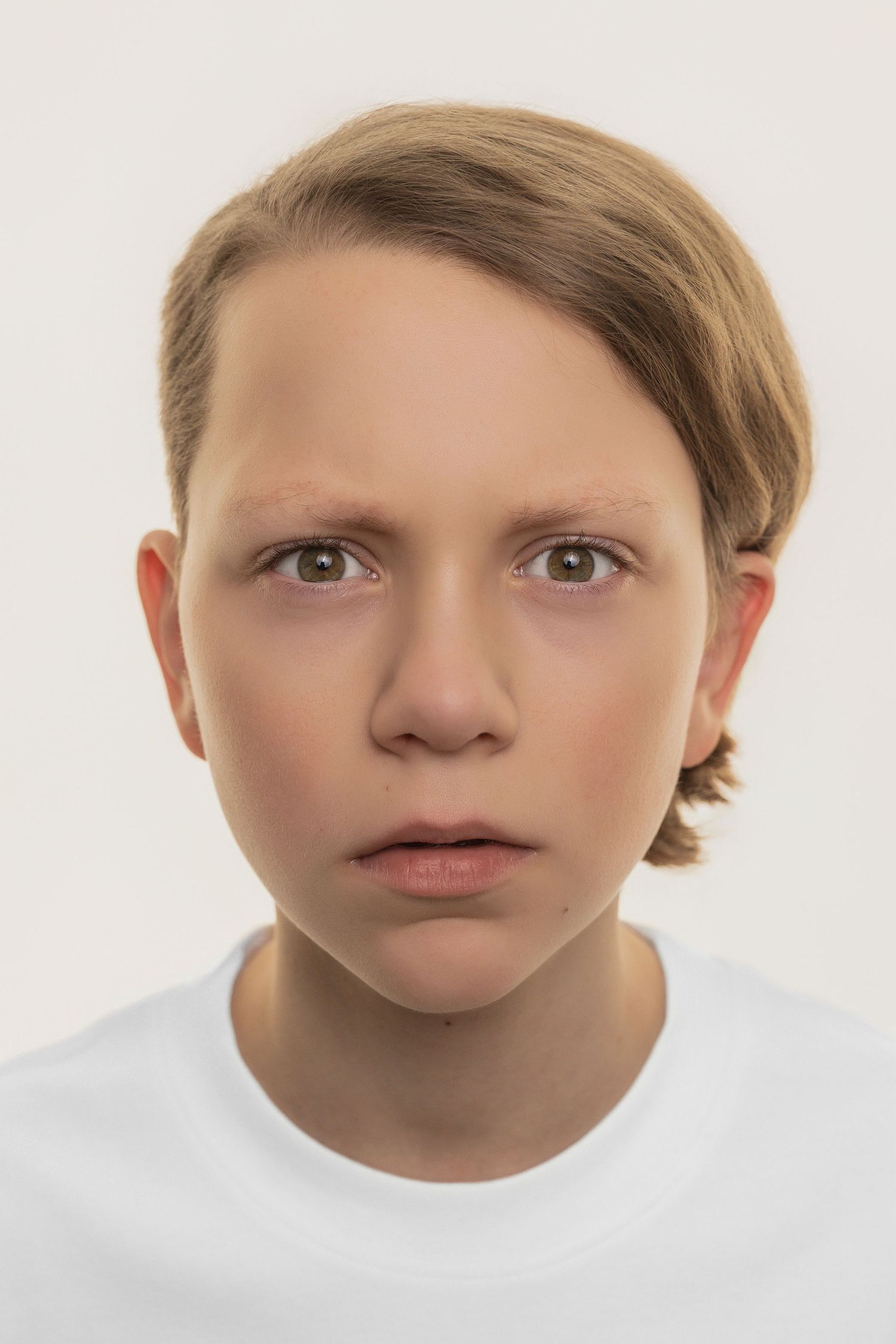 Eine Abfolge von fünf ähnlichen Gesichtsausdrücken, die subtile Veränderungen im emotionalen Zustand vor einem weißen Hintergrund zeigen.