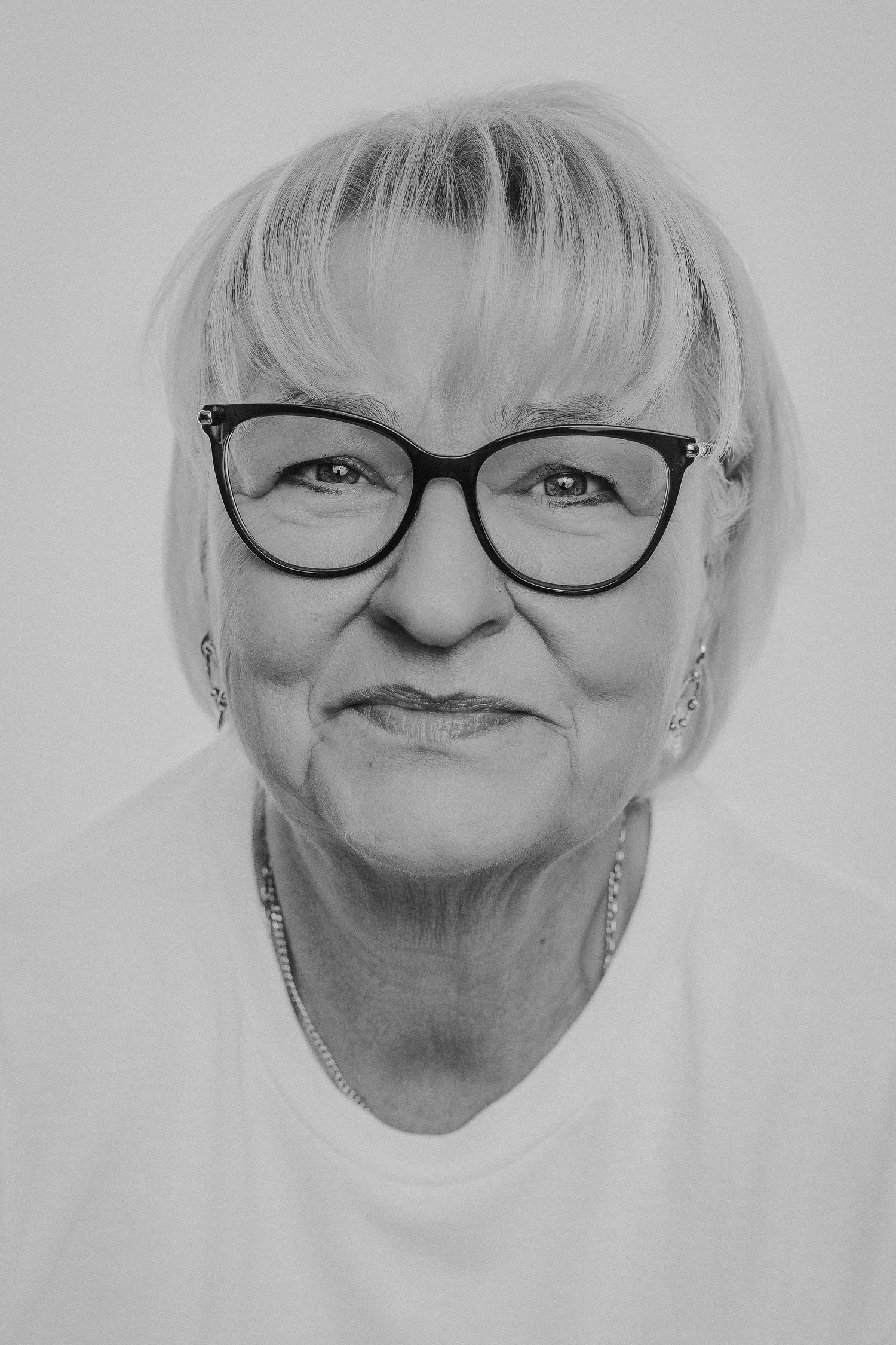 A series of black and white portraits showing expressions and emotions while wearing glasses.