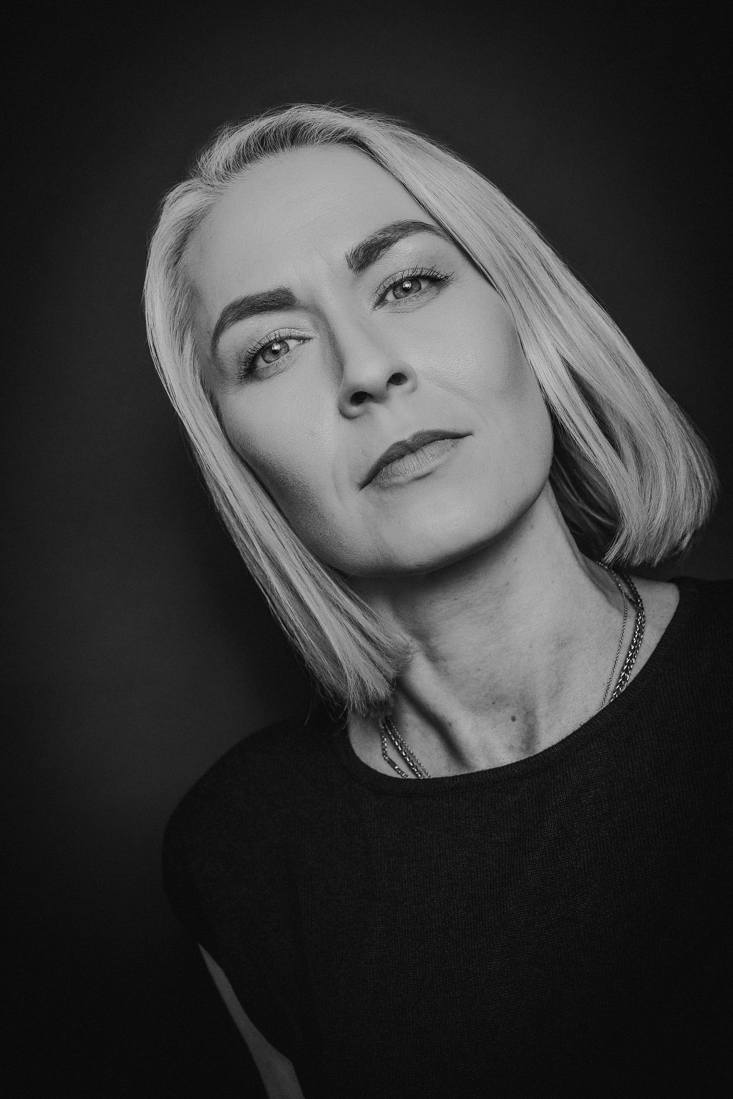 A series of dramatic black and white portraits showing different angles of a blonde woman against a dark background.
