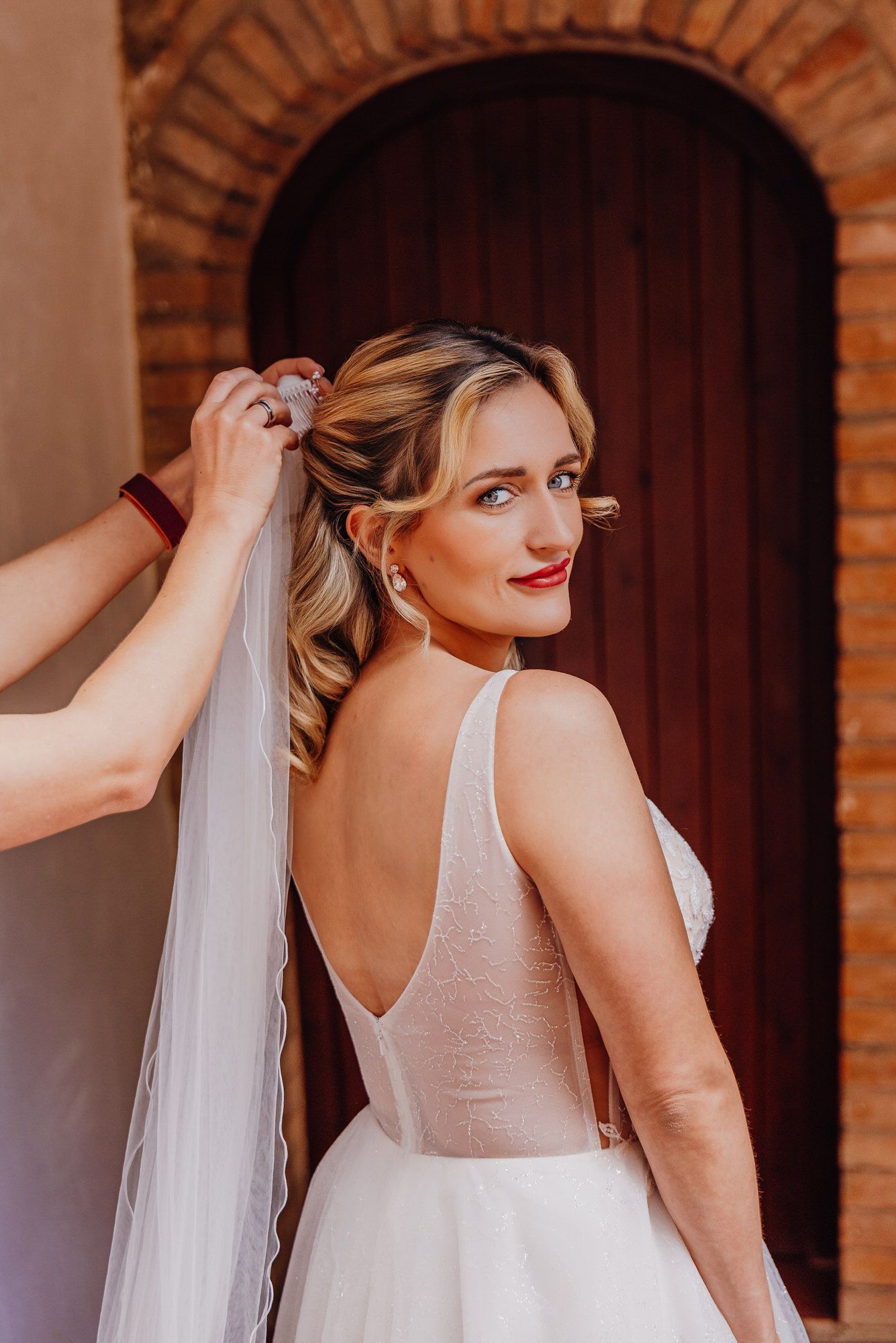 A series of photos showing a bride having her delicate white veil adjusted during wedding preparations.