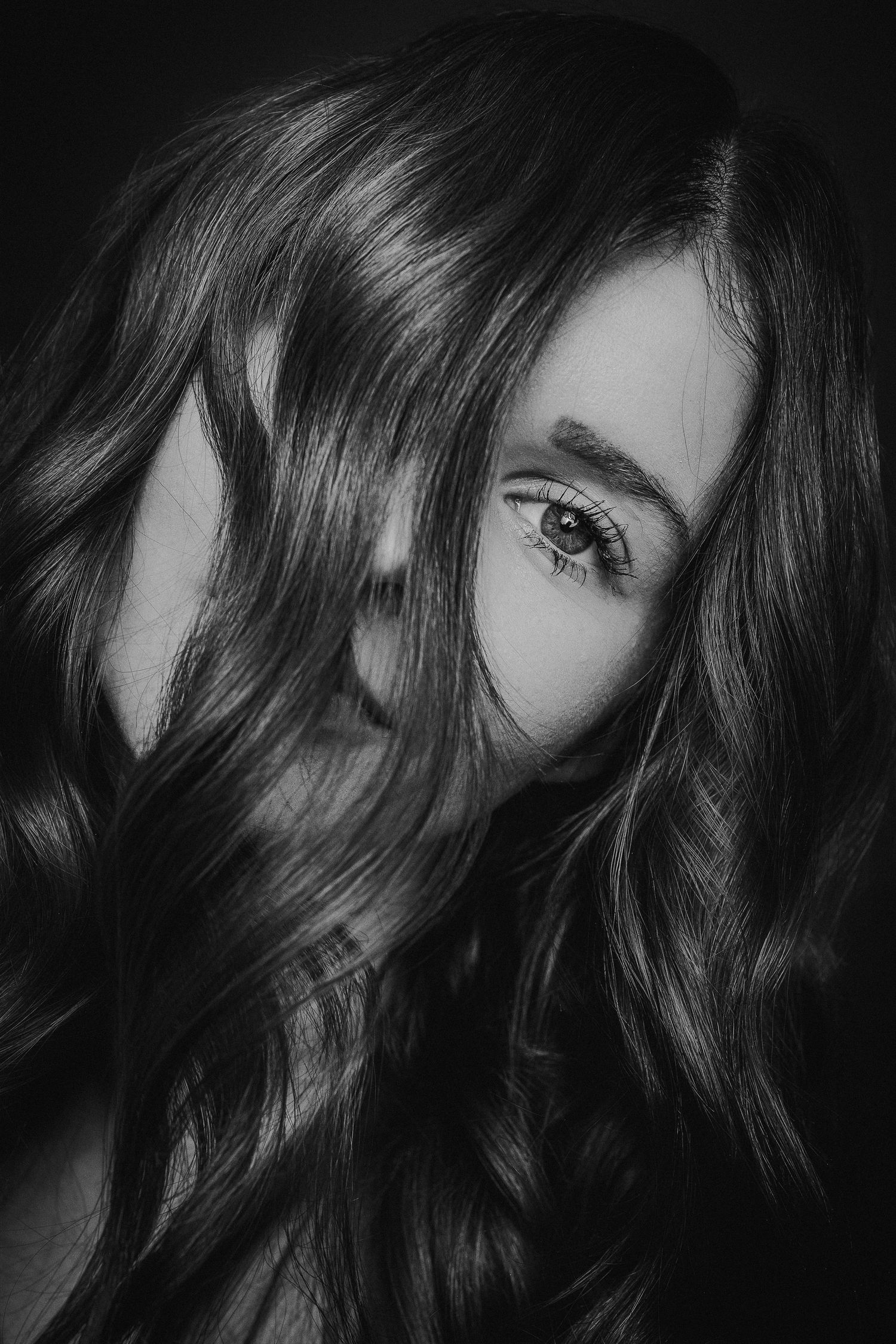 Black and white artistic portrait series showing close-up shots of long wavy hair and partial facial features in shadow.