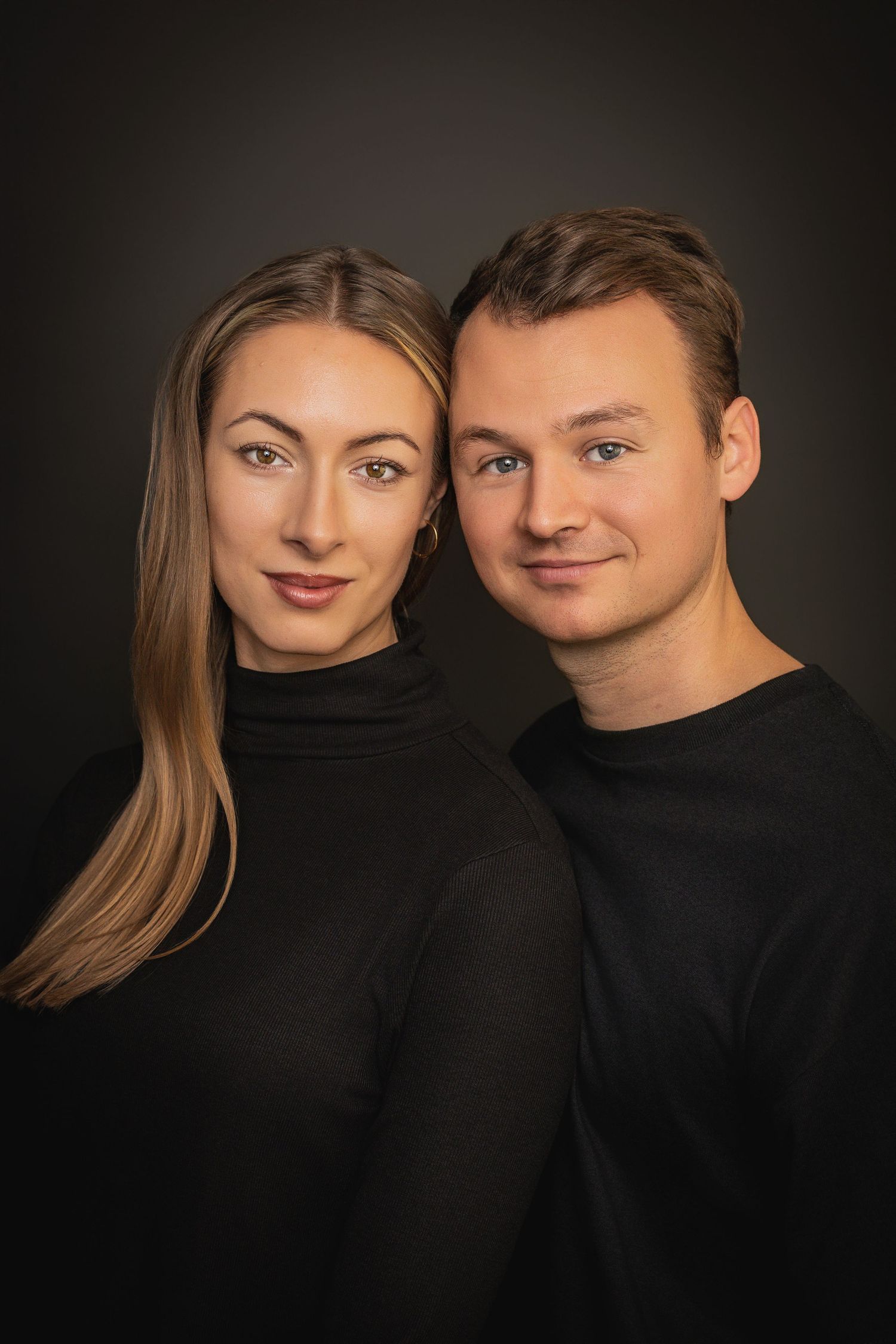 Artistic black and white portrait series showing a couple in black clothing against dark background.