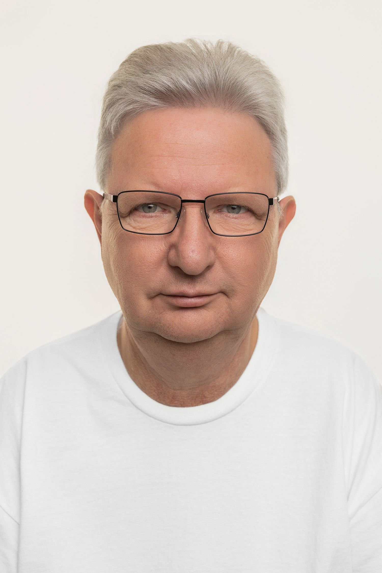 Four headshots of a person wearing glasses and a white shirt showing different facial expressions.