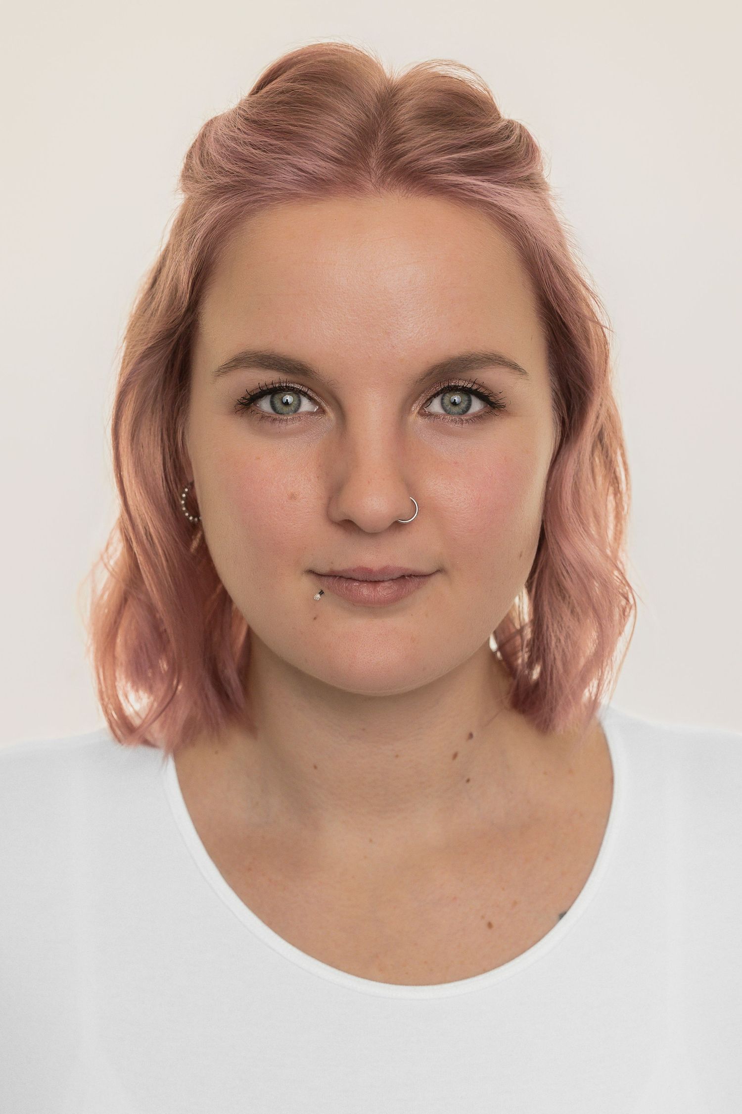 A series of close-up facial portraits with pink hair against a white background showing different winking expressions.