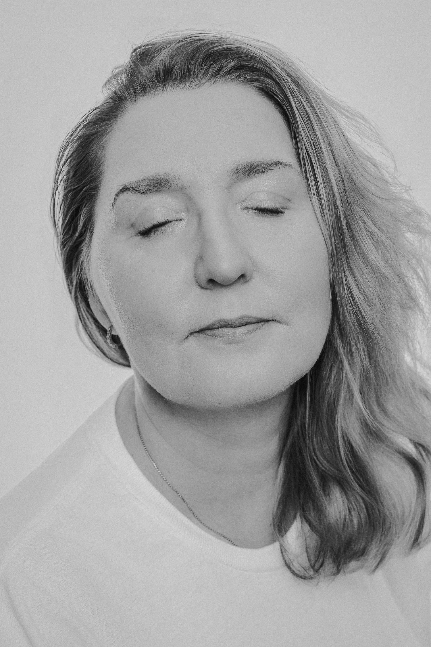 A series of black and white portraits showing a person with closed eyes in different resting poses against a white background.