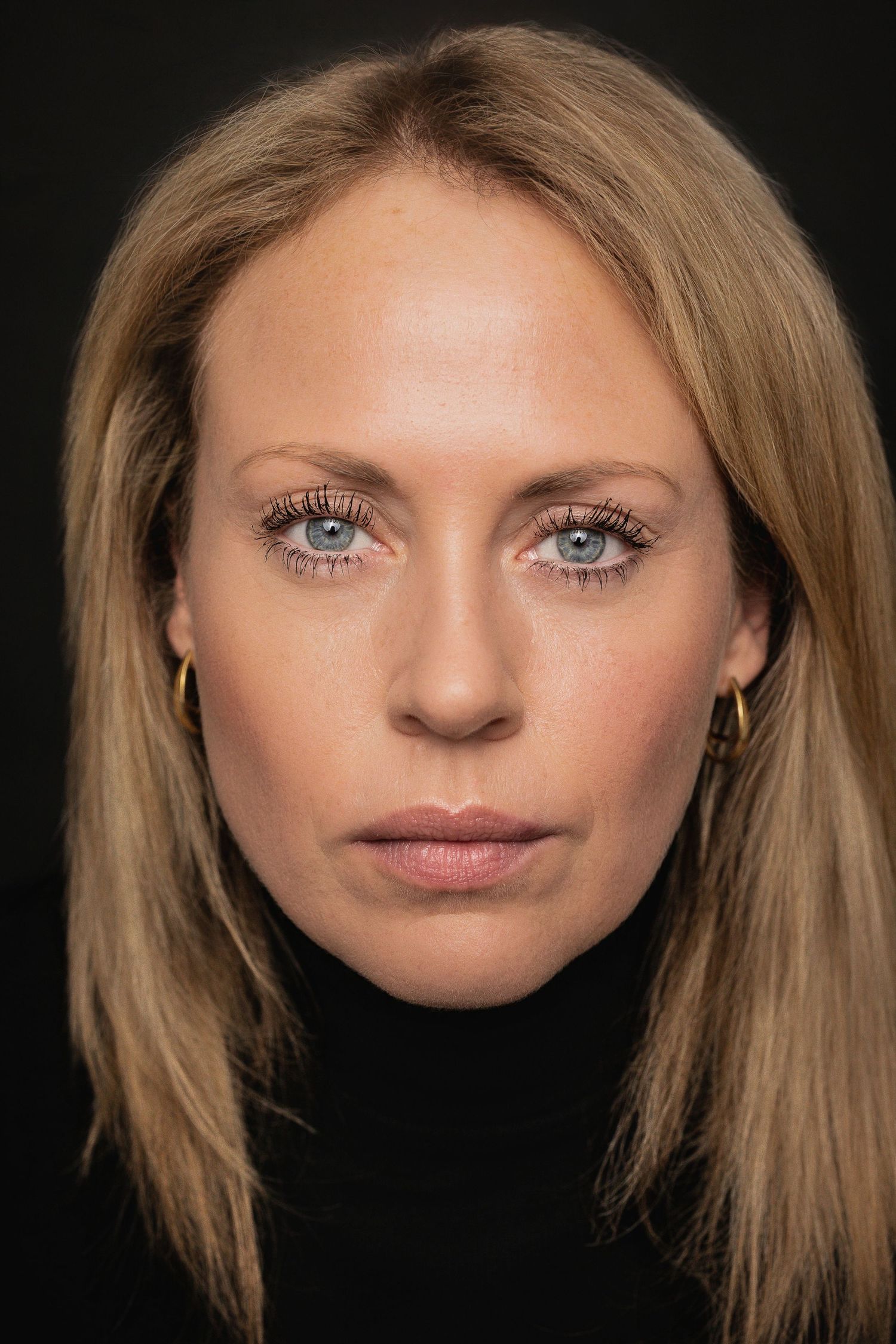 A series of close-up portrait shots showing different angles of a person with blonde hair and blue eyes against a dark background.