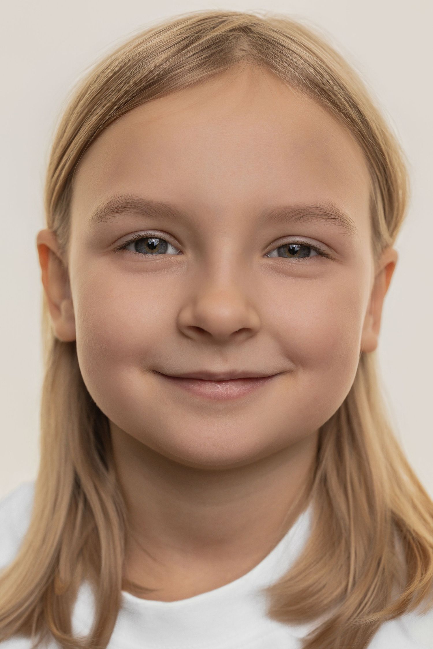 A sequence of five close-up portraits showing a child's changing facial expressions from neutral to smiling.