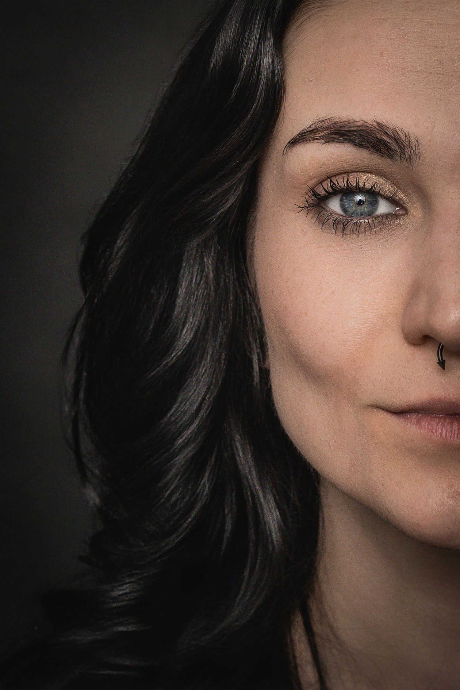 Close-up portrait sequence showing dark hair and facial features against a black background in dramatic lighting.