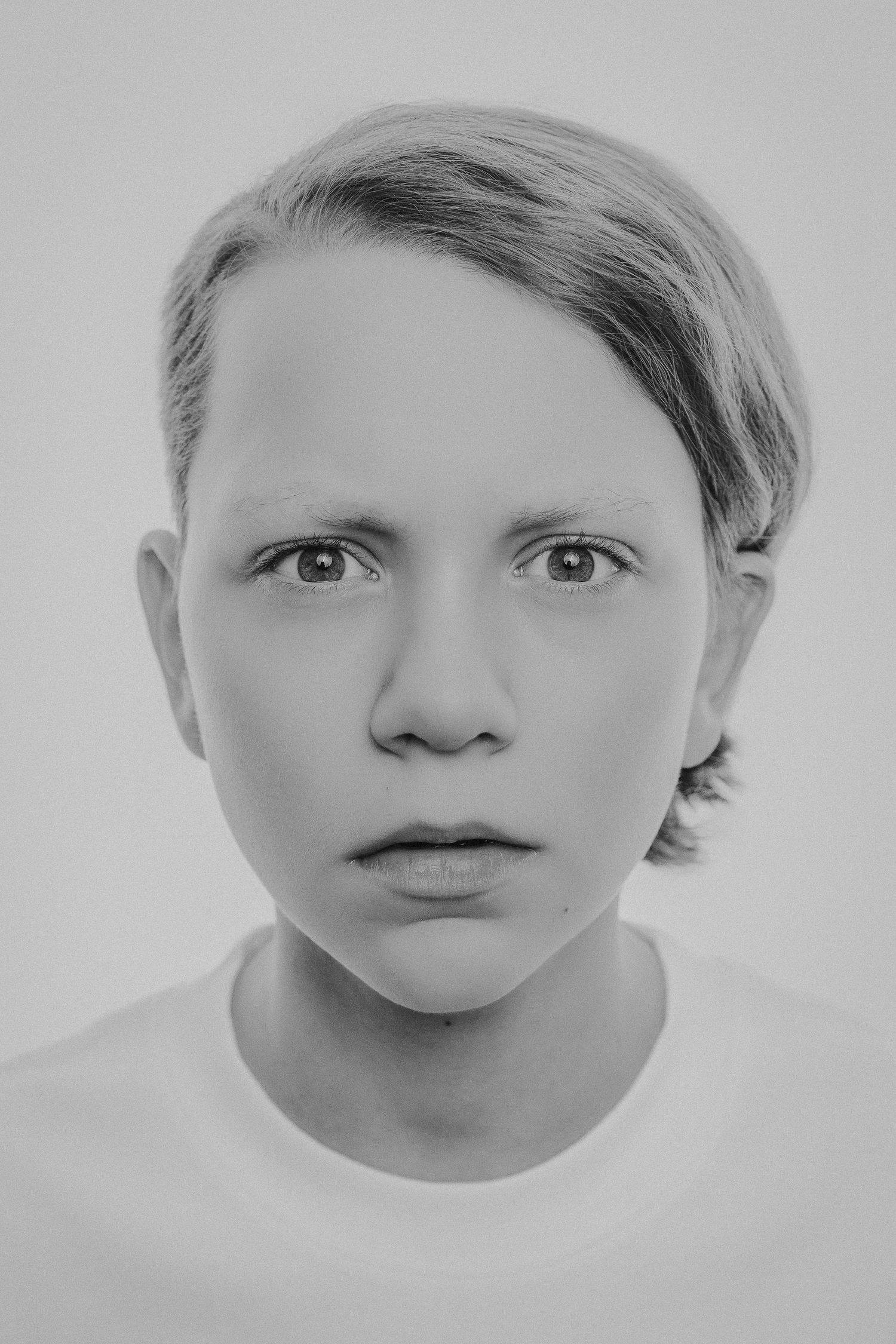 A series of black and white portrait photographs showing different facial expressions and angles of the same subject.