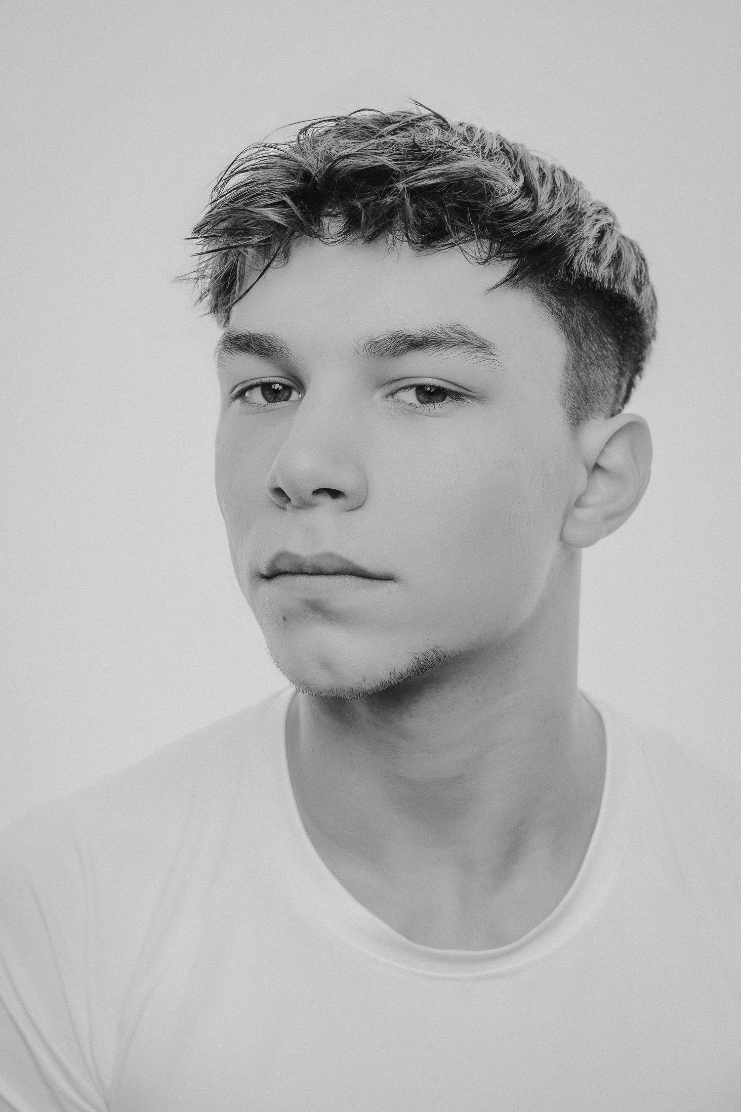 Black and white portrait series showing different angles of a person's face against a light background.