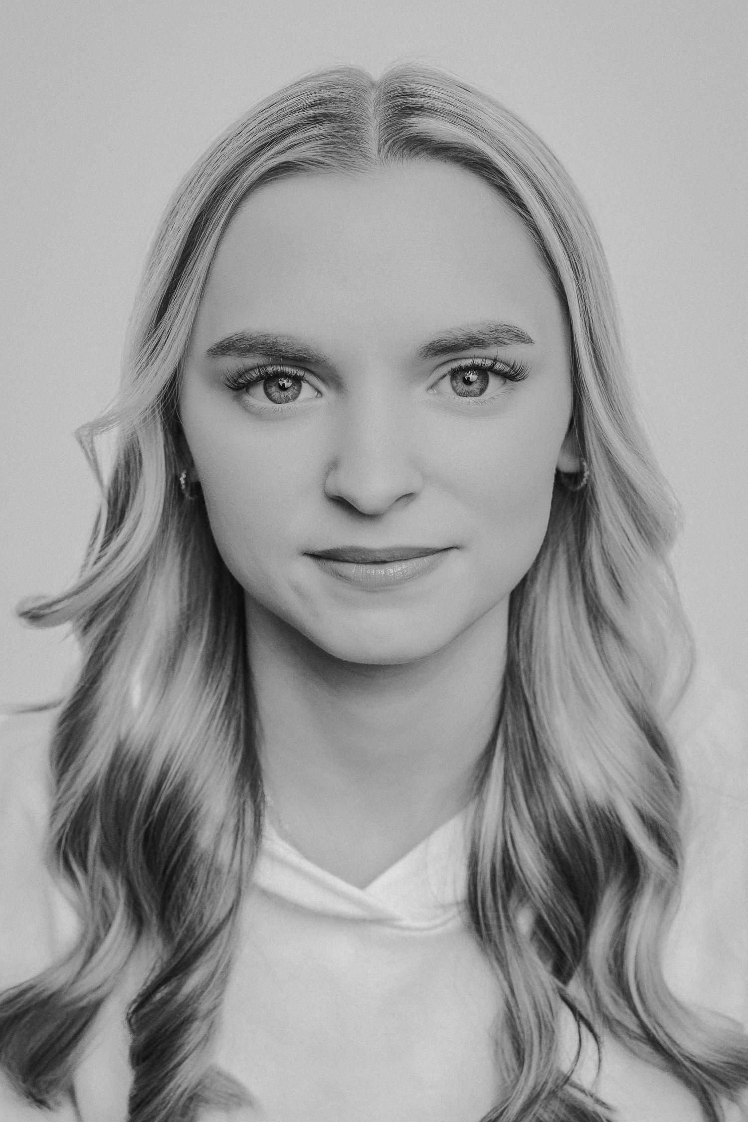 A black and white portrait series showing the same person with different expressions and poses against a light background.