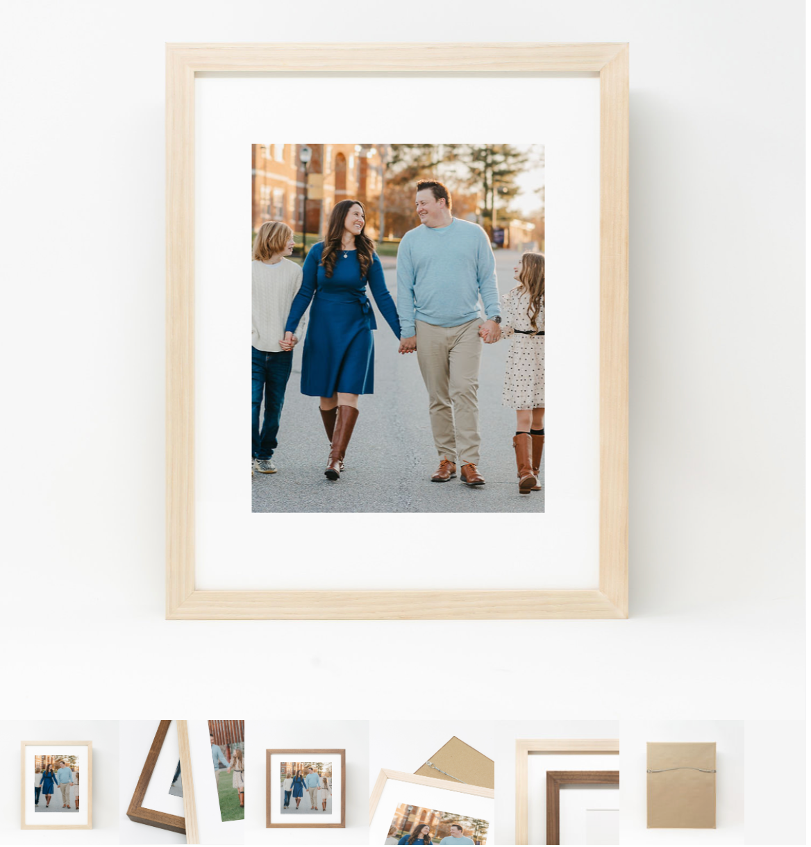 Gallery wall display in a home featuring multiple framed family photographs arranged in a clean, modern layout.