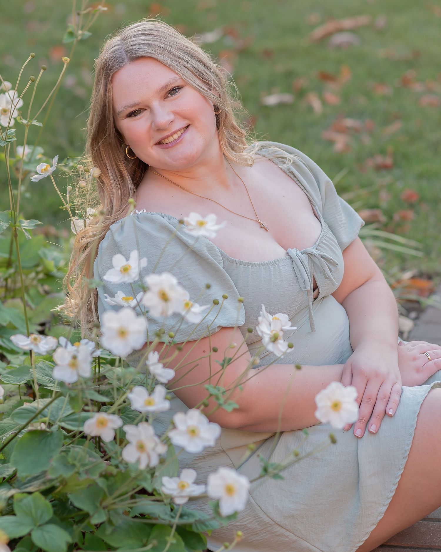 Multiple poses on grass with white Japanese anemone flowers in a light gray dress during an outdoor senior photo session in new hampshire