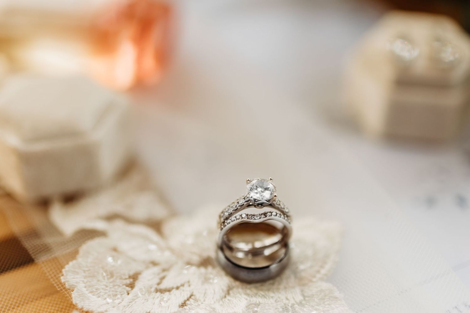 Wedding rings and delicate lace details create an elegant bridal still life composition on a light surface.