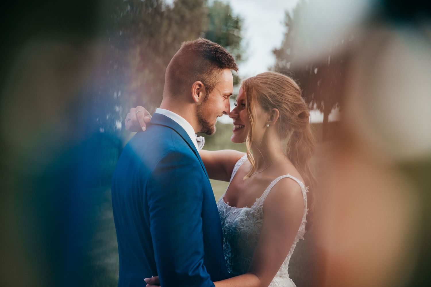 A romantic moment between newlyweds during their outdoor wedding ceremony captured with dreamy bokeh effect.