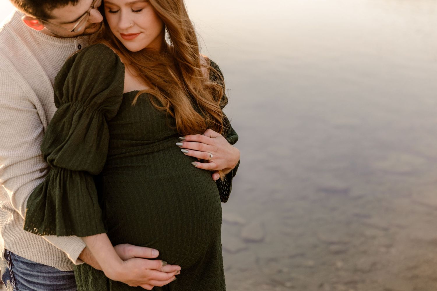 Intimate couple embracing during sunset photoshoot at golden hour.