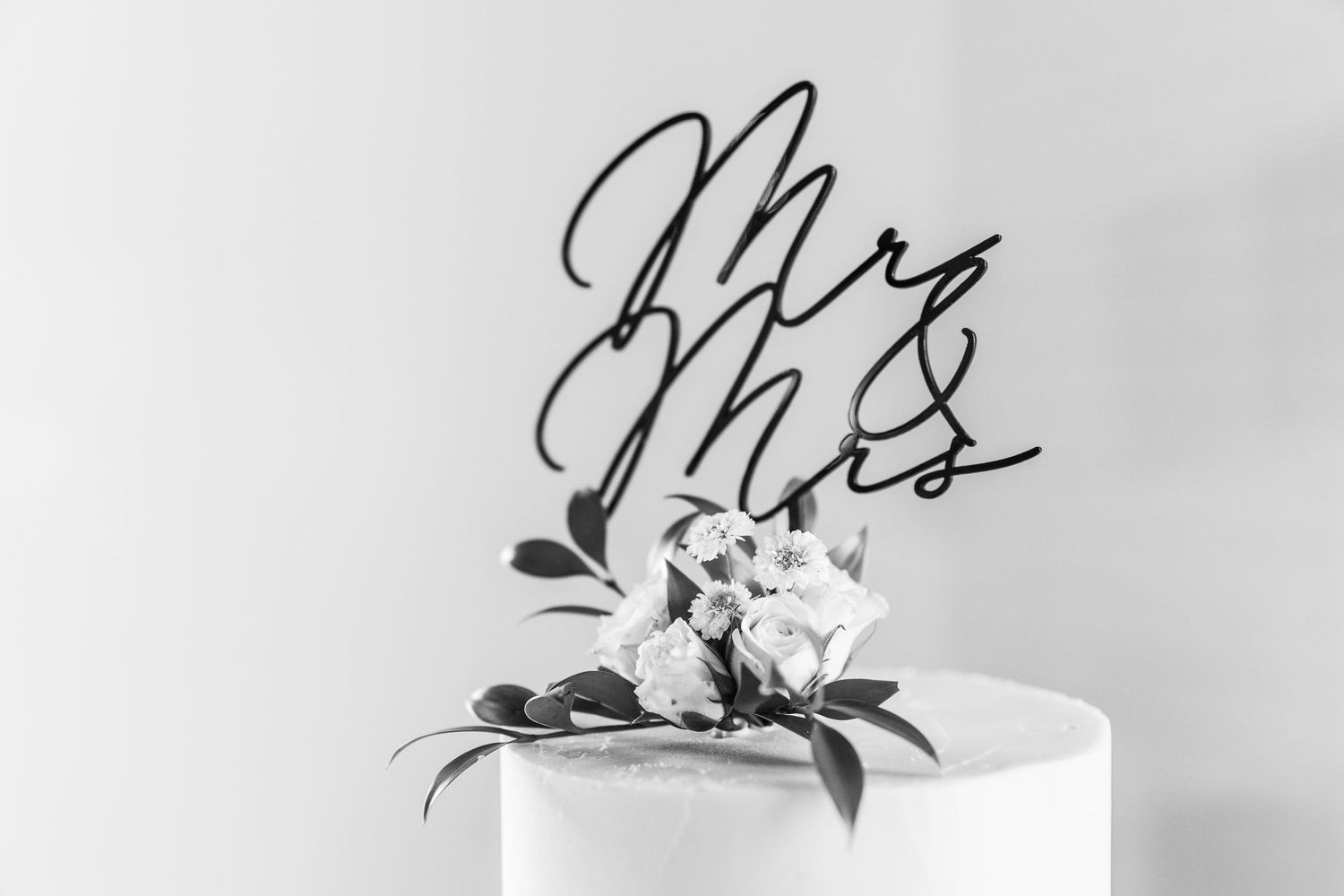 mr. and mrs. wedding cake topper with flowers.
