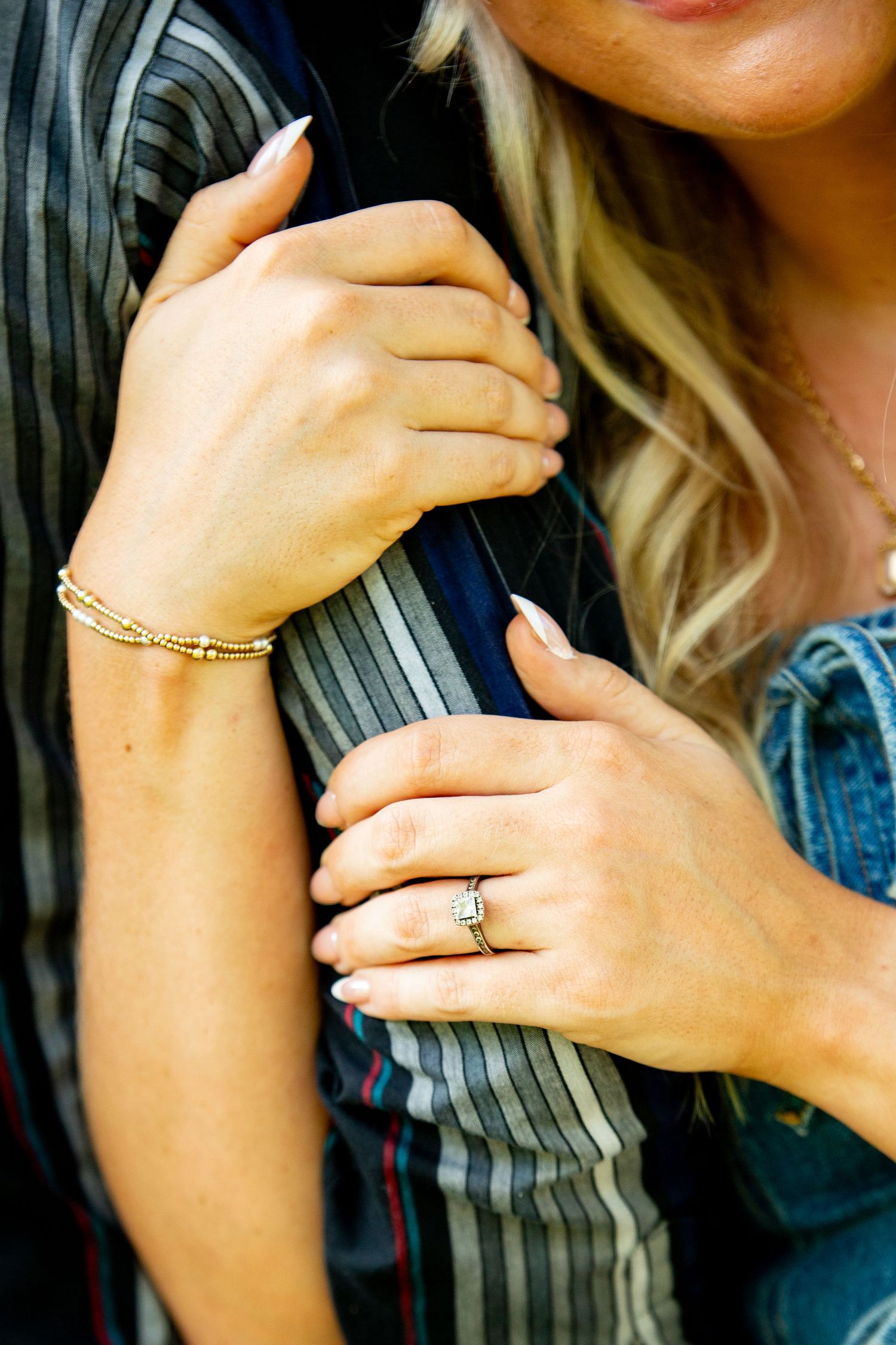 Close-up shots of hands showing delicate jewelry and rings against a dark background.