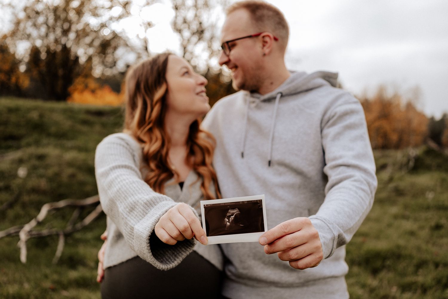 Glückliche werdende Eltern präsentieren das erste Ultraschallbild ihres Babys voller Vorfreude.