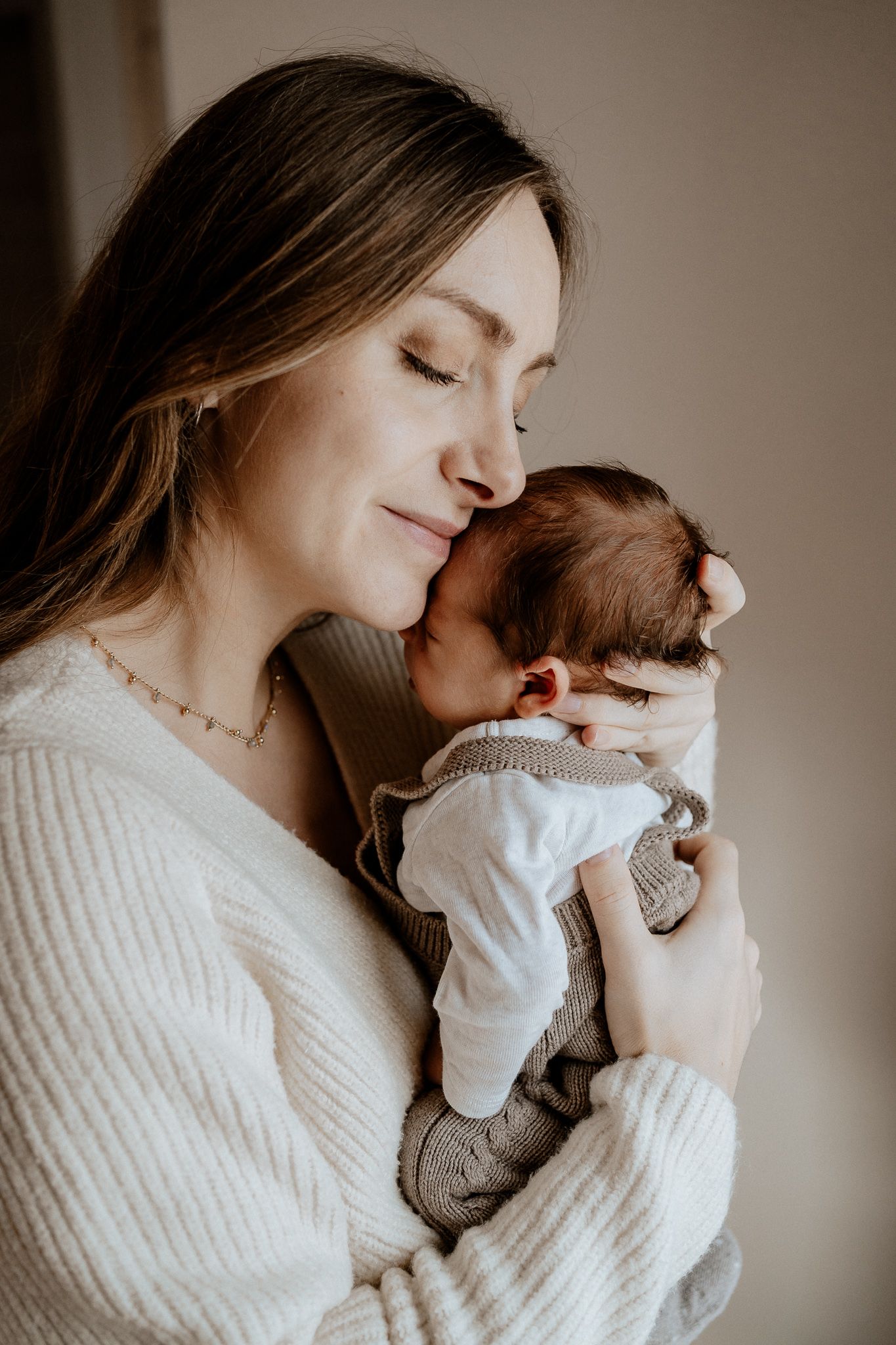 Mutter hält ihr Baby liebevoll im Arm und schenkt ihm Geborgenheit.