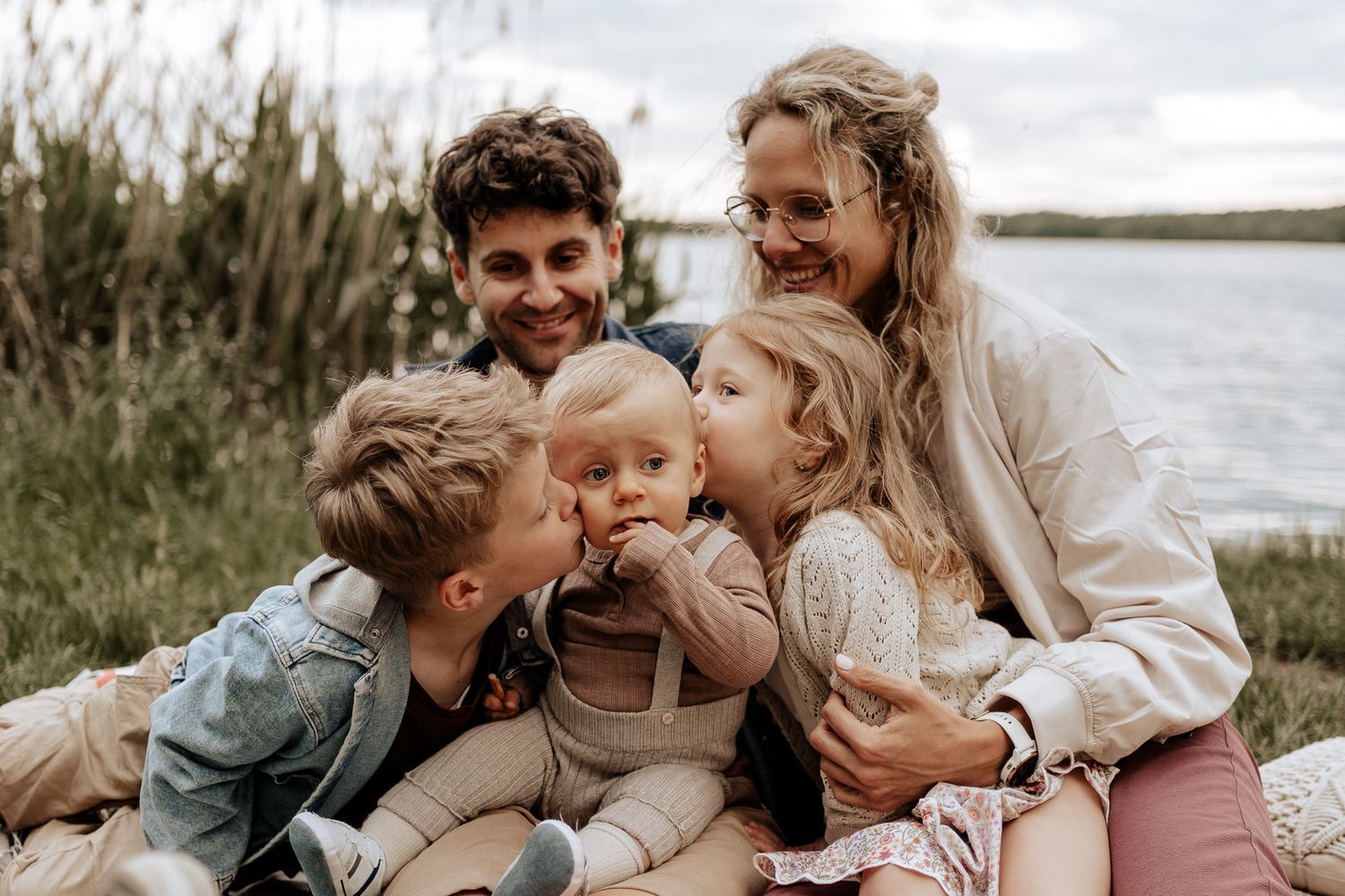 Natürliche Familienfotografie in Hilpoltstein – Eltern und Kinder sitzen eng beieinander und teilen einen liebevollen, authentischen Moment.