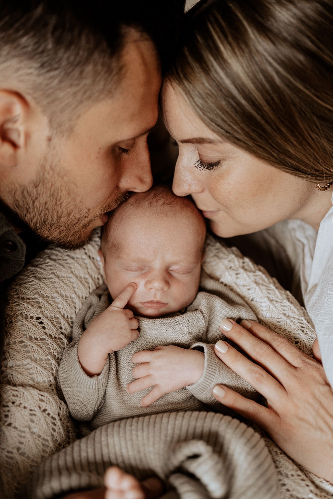 Eltern mit ihrem Neugeborenen – inniger und liebevoller Moment beim Babyshooting.