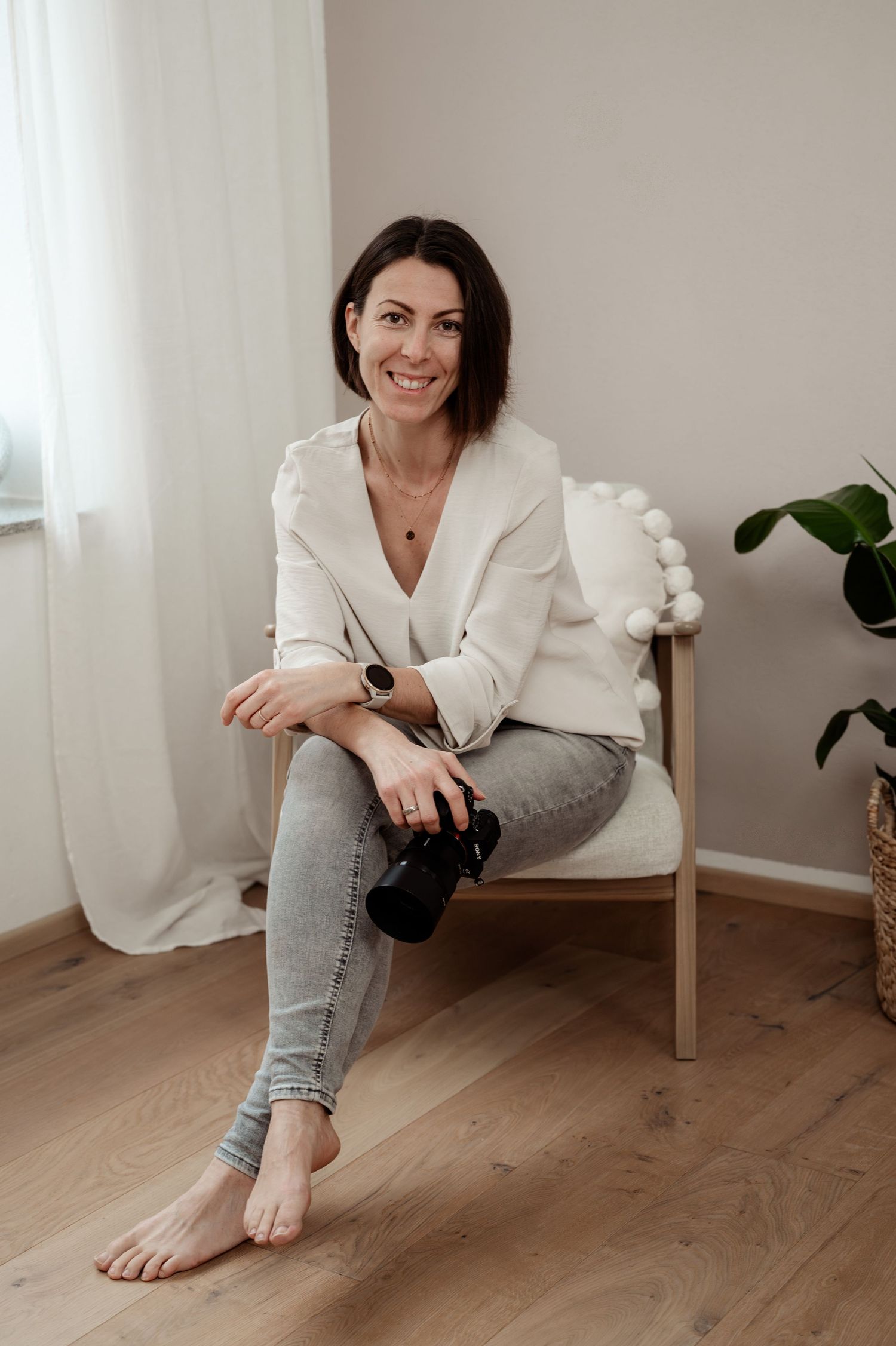 Familienfotografin sitzt entspannt mit Kamera – natürliches und authentisches Portrait.
