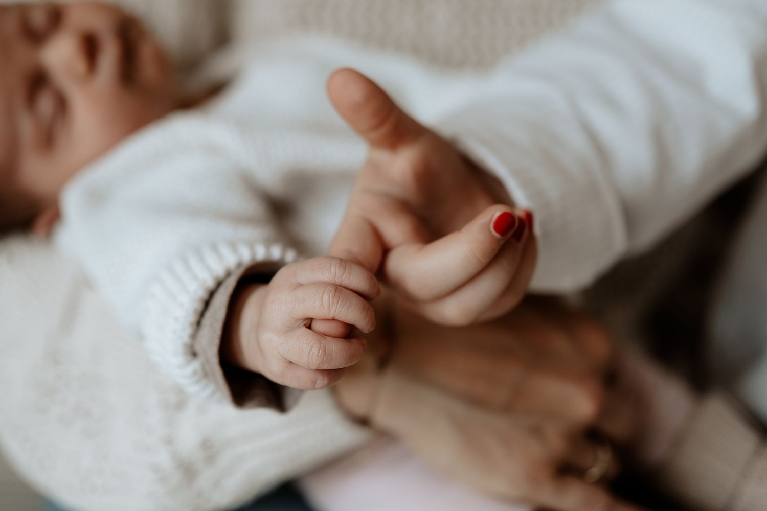 Detailaufnahme von Babyhand und Geschwisterhand – innige Nähe bei einem Neugeborenenshooting in Hilpoltstein.