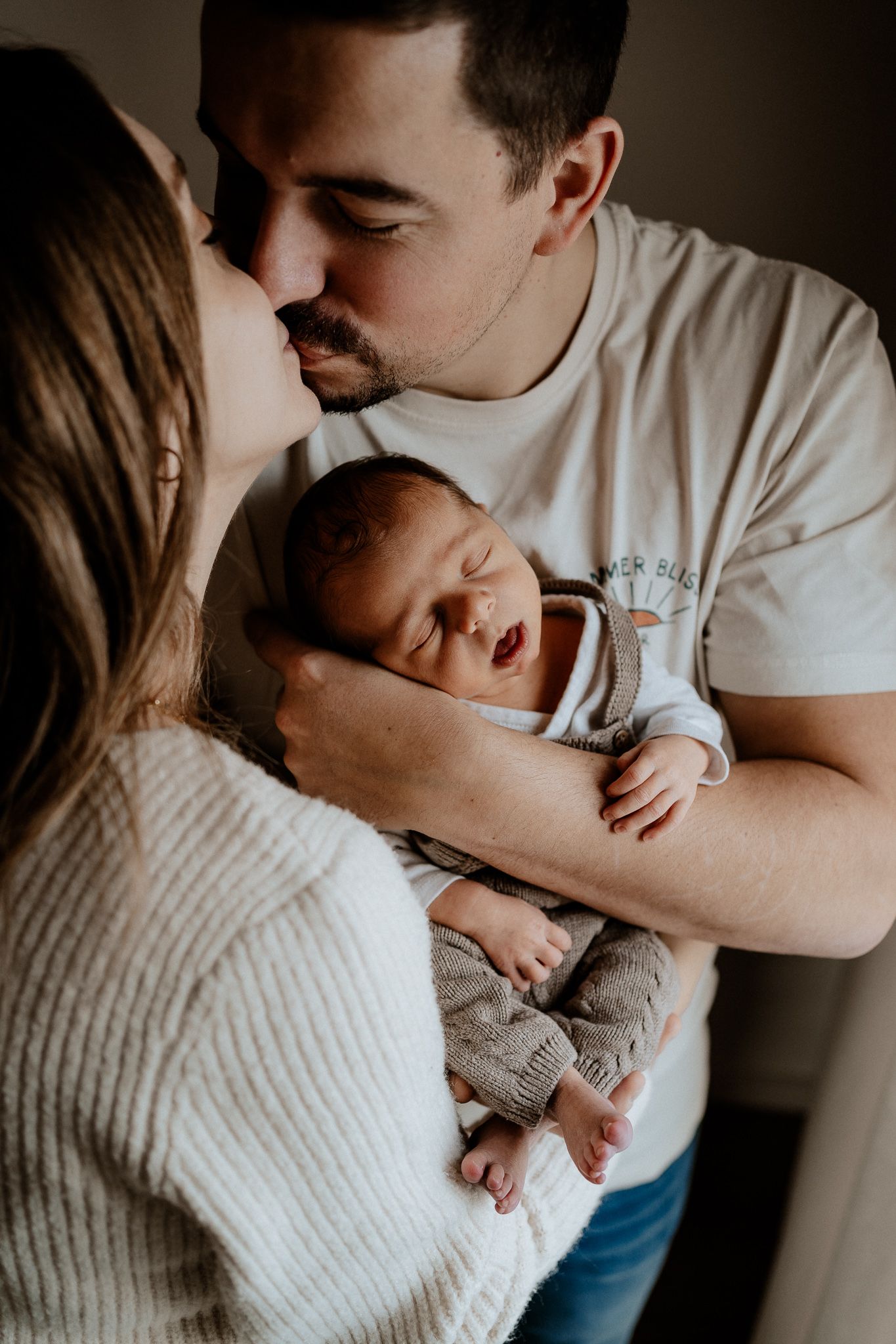 Natürliche Neugeborenenfotografie in Hilpoltstein: Eltern schenken ihrem Baby einen liebevollen Kuss.