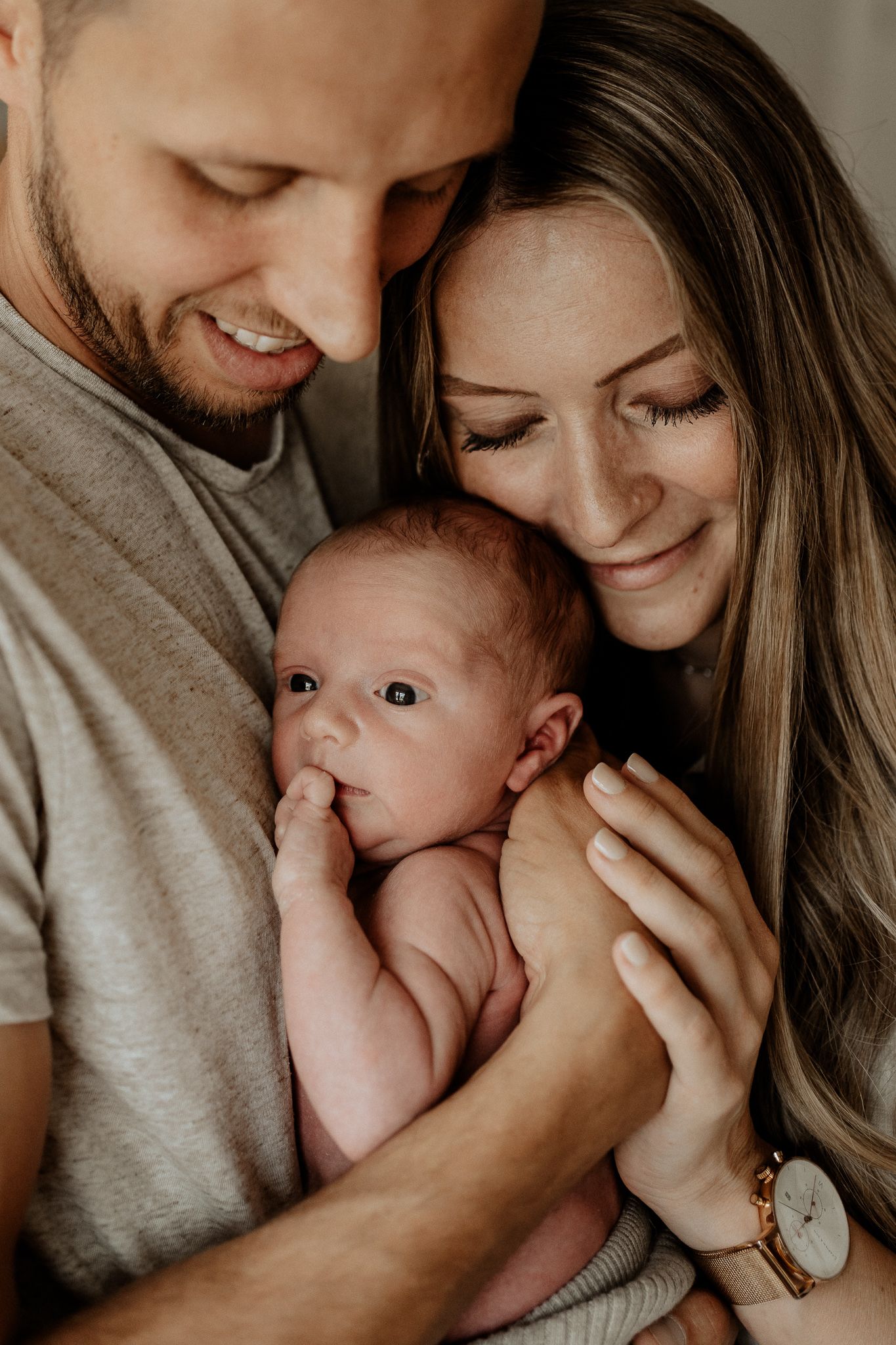 Natürliche Babyfotografie in Hilpoltstein: Eltern halten ihr Baby behutsam bei sich.