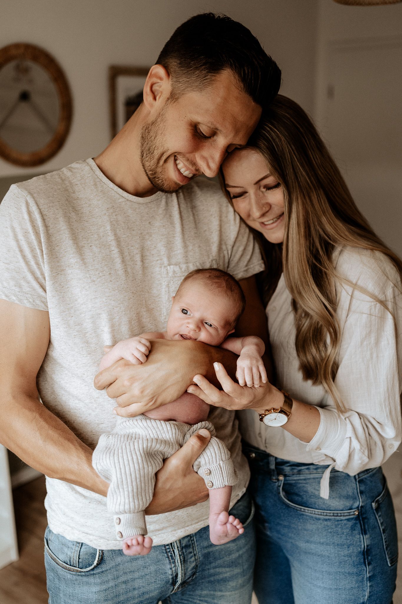 Emotionale Neugeborenenfotografie: Eltern halten ihr Baby nah bei sich in einem Augenblick voller Geborgenheit und Liebe.