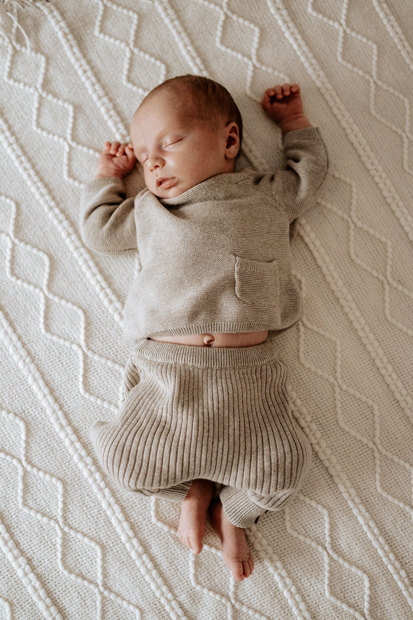 Neugeborenes Baby liegt ruhig auf einer weichen Decke – natürliche Neugeborenenfotografie.