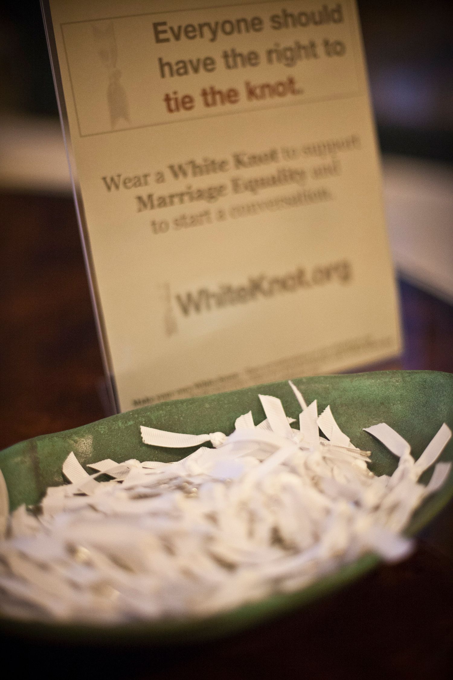White Knot marriage equality awareness display with white ribbon knots in a green bowl.