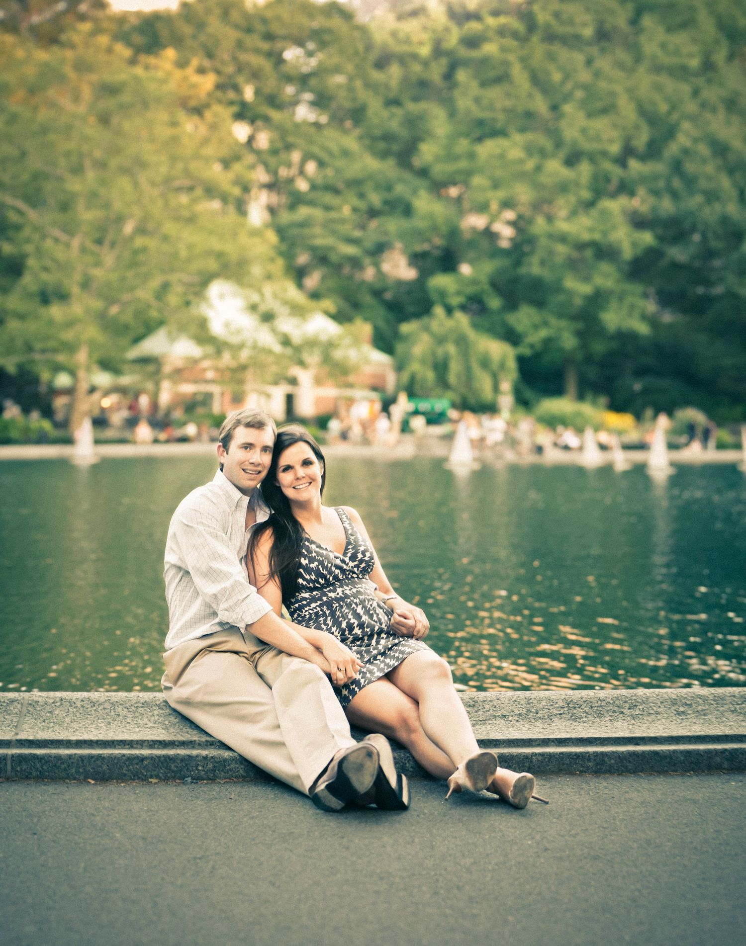 Couple sitting together by a pond in Central Park, New York City, on a warm summer day.