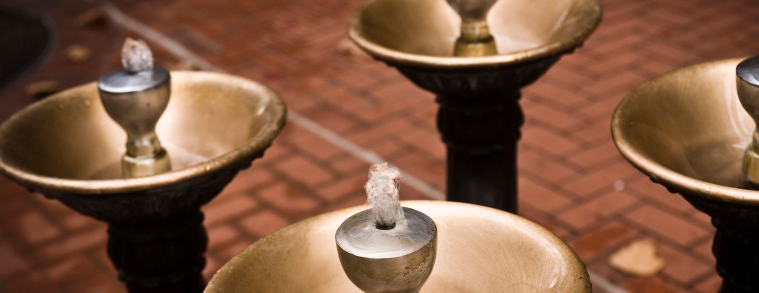 Vintage brass drinking water fountains on brick plaza in outdoor public space.